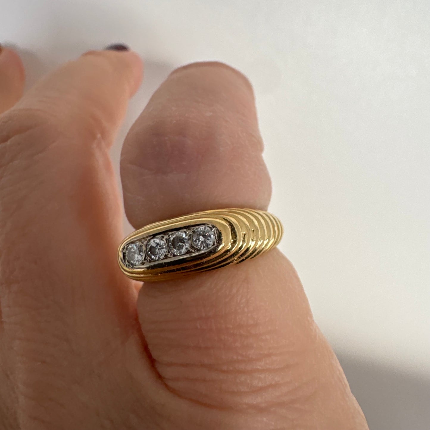 טבעת זהב צהוב 14 קראט בעיצוב אליפטי מוארך, משובצת חמישה יהלומים עגולים בשיבוץ תעלה.