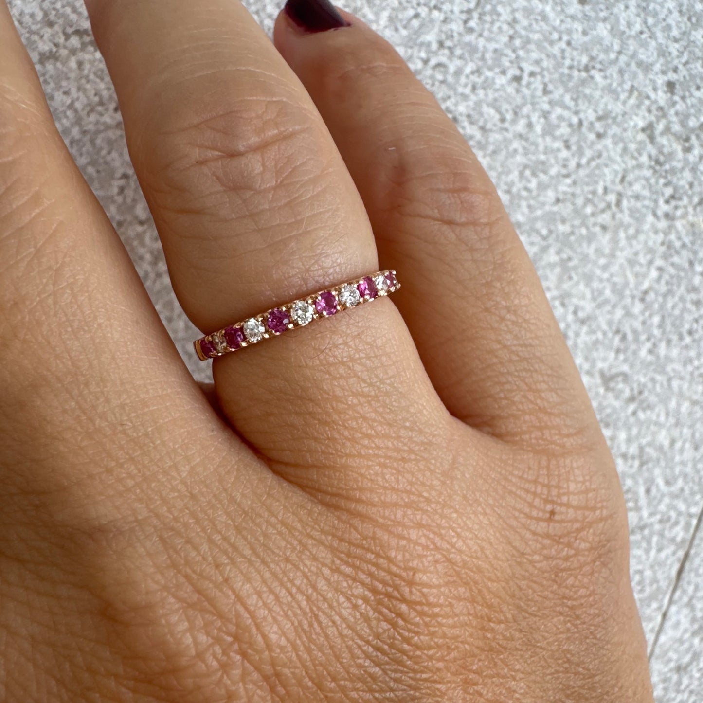 טבעת חצי איטרניטי מזהב אדום 14 קראט, משובצת ברצף של אבני רובי ויהלומים .