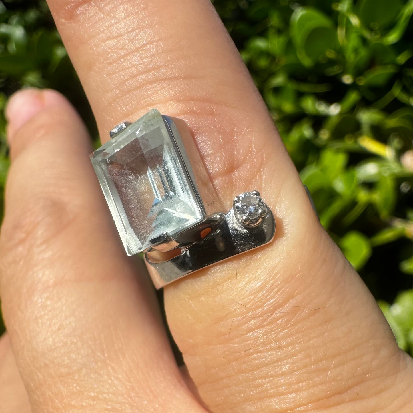 18K gold ring set with a rectangular step-cut Aquamarine set in a sculptural white gold band & a sparkling Diamond