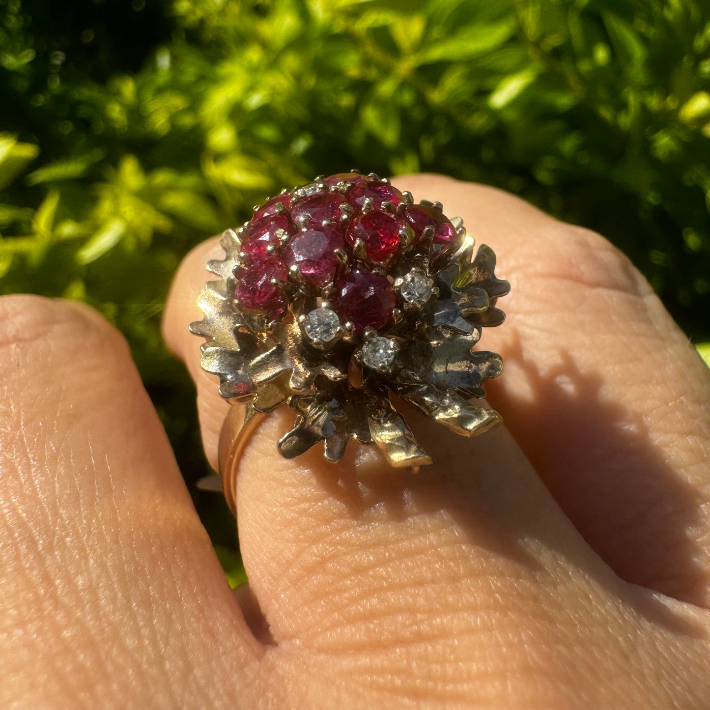 14K gold ring set with a vibrant cluster of deep red rubies and sparkling diamonds.