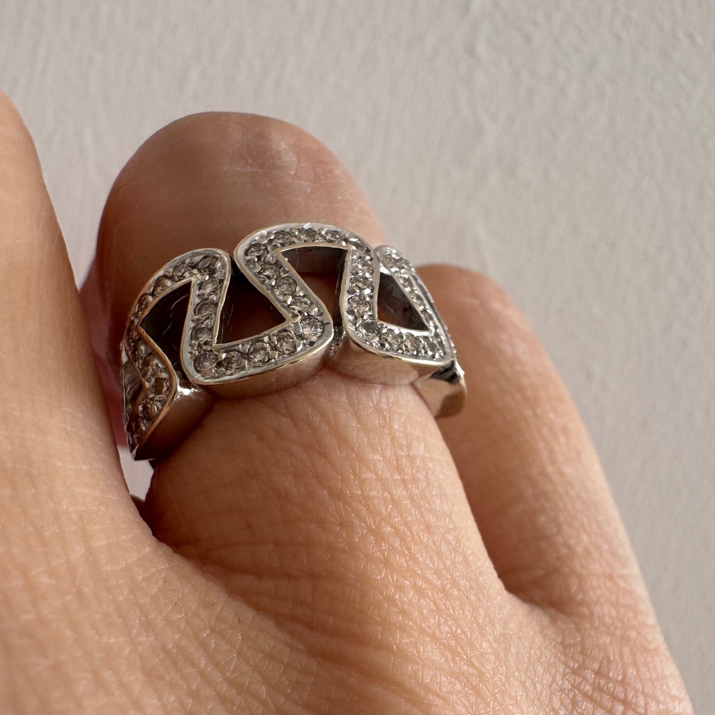 טבעת זהב לבן 18 קראט מעוצבת בחוליות גאומטריות פתוחות, משובצות יהלומים קטנים ומבריקים