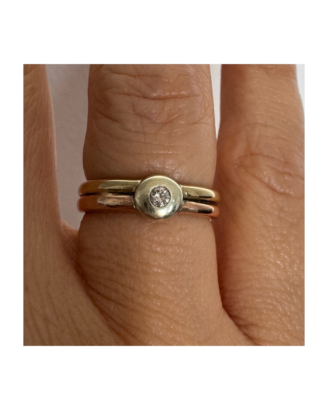 טבעת זהב 10 קראט בעיצוב מינימליסטי ונקי, משובצת יהלום מרכזי במסגרת חלקה (Bezel).