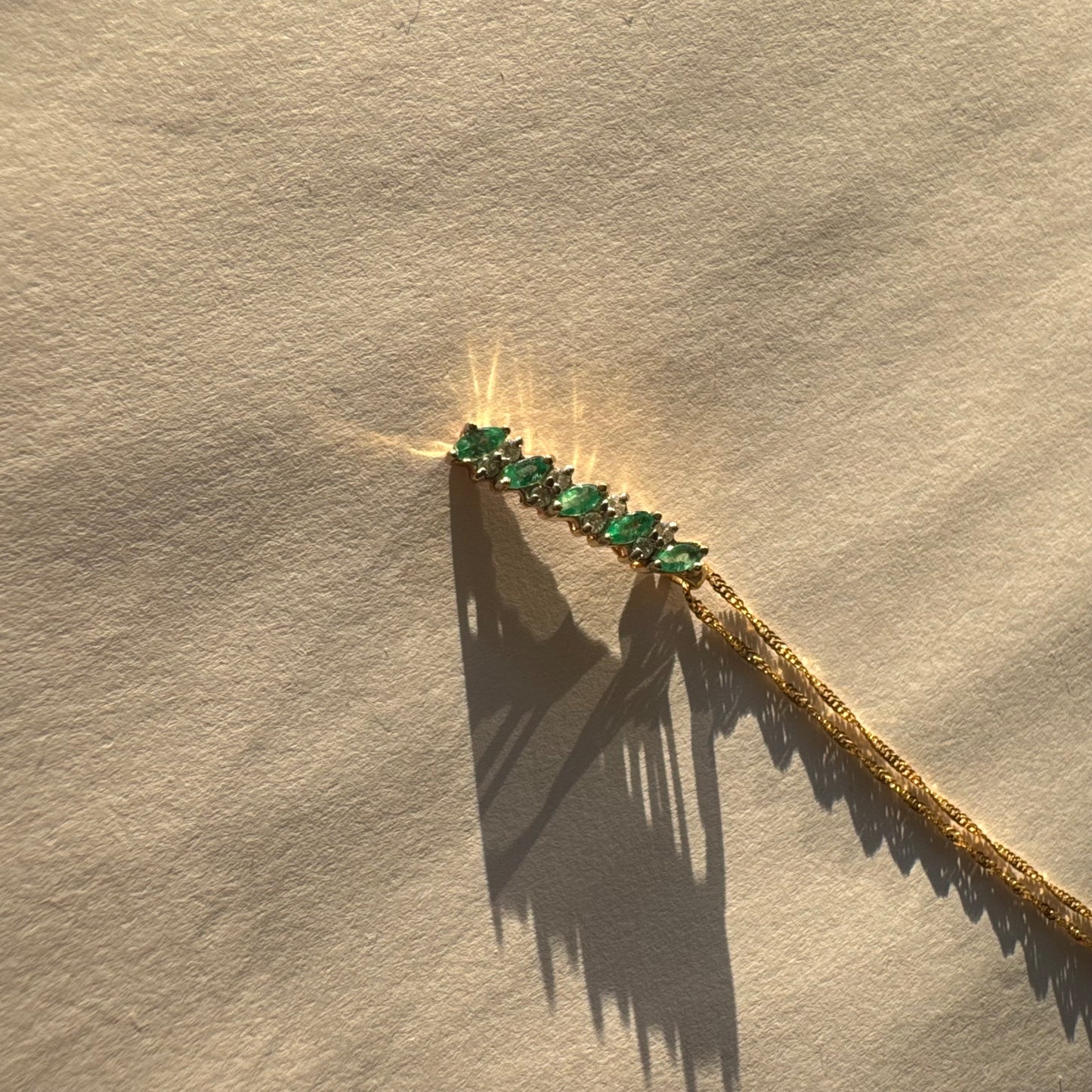 תליון זהב 14 קראט משובץ אמרלדים בחיתוך מרקיזה ויהלומים נוצצים. 