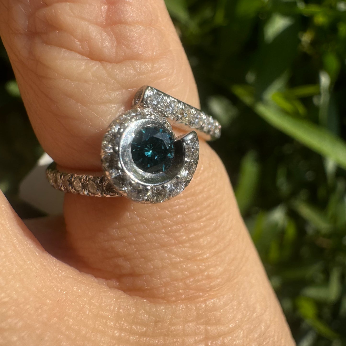 18K gold ring set with a vivid blue Diamond at its heart, embraced by a shimmering halo of white diamonds and a bold open design