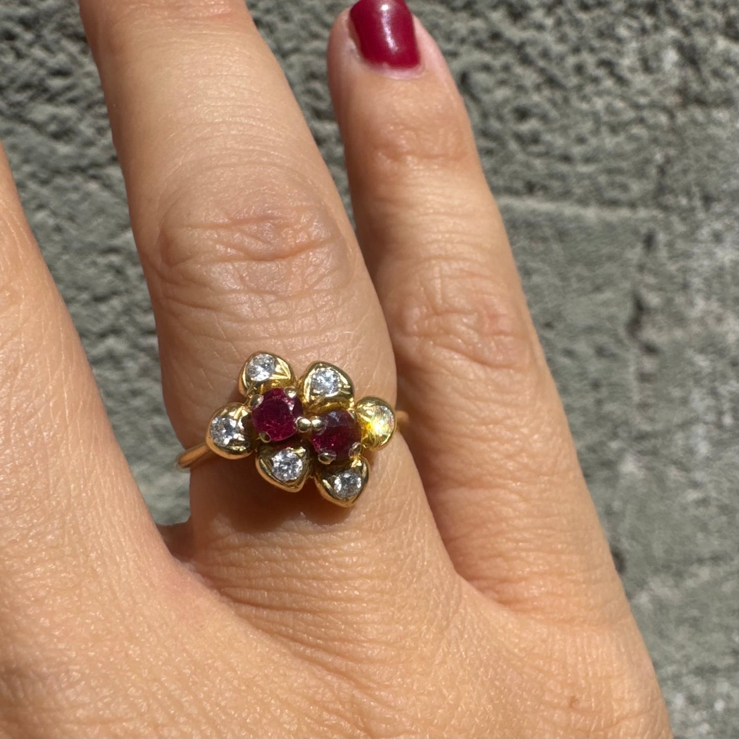 18K gold ring designed like a flower, set with two deep red Rubies and sparkling Diamonds