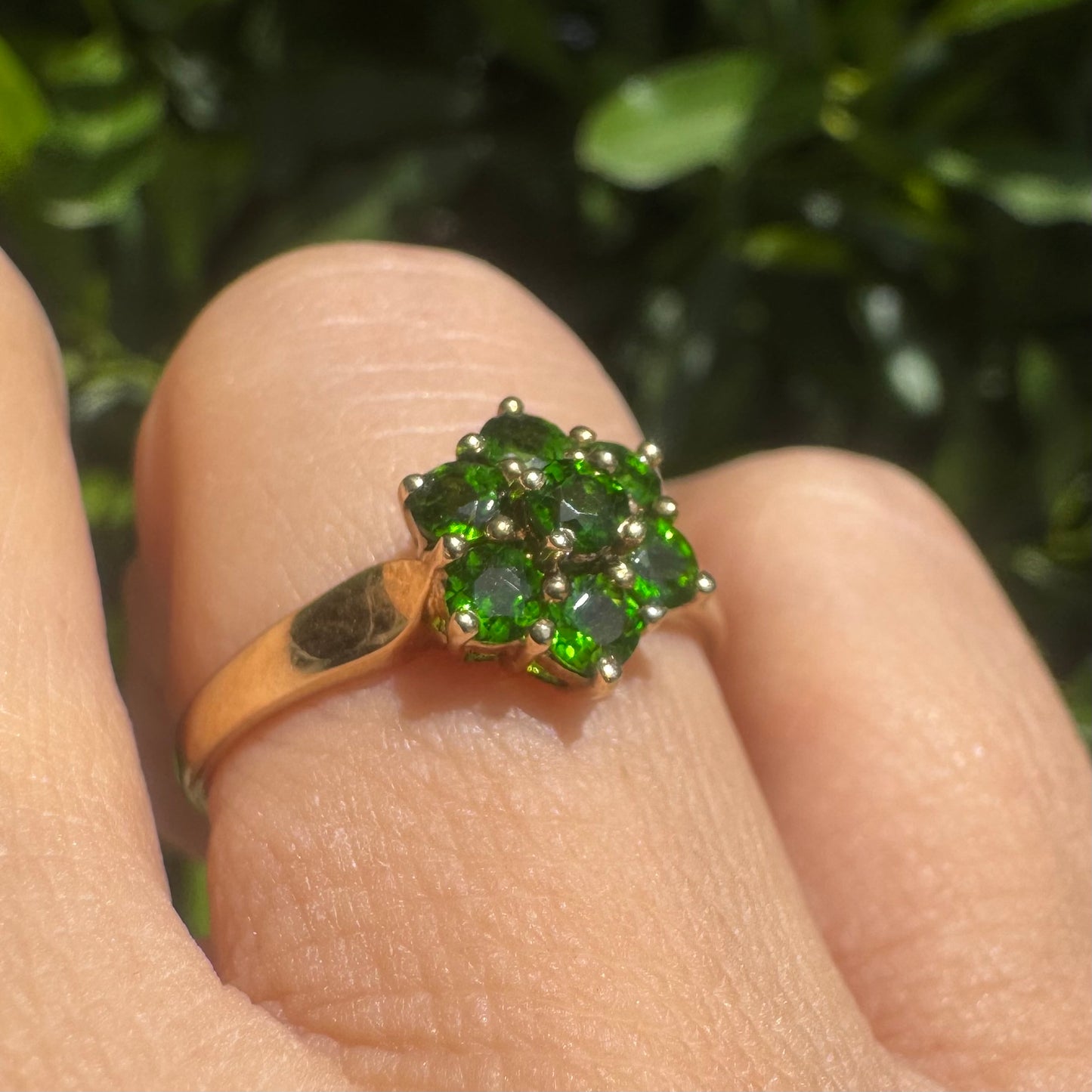 10K gold ring set with vivid green gemstones in a delicate floral cluster