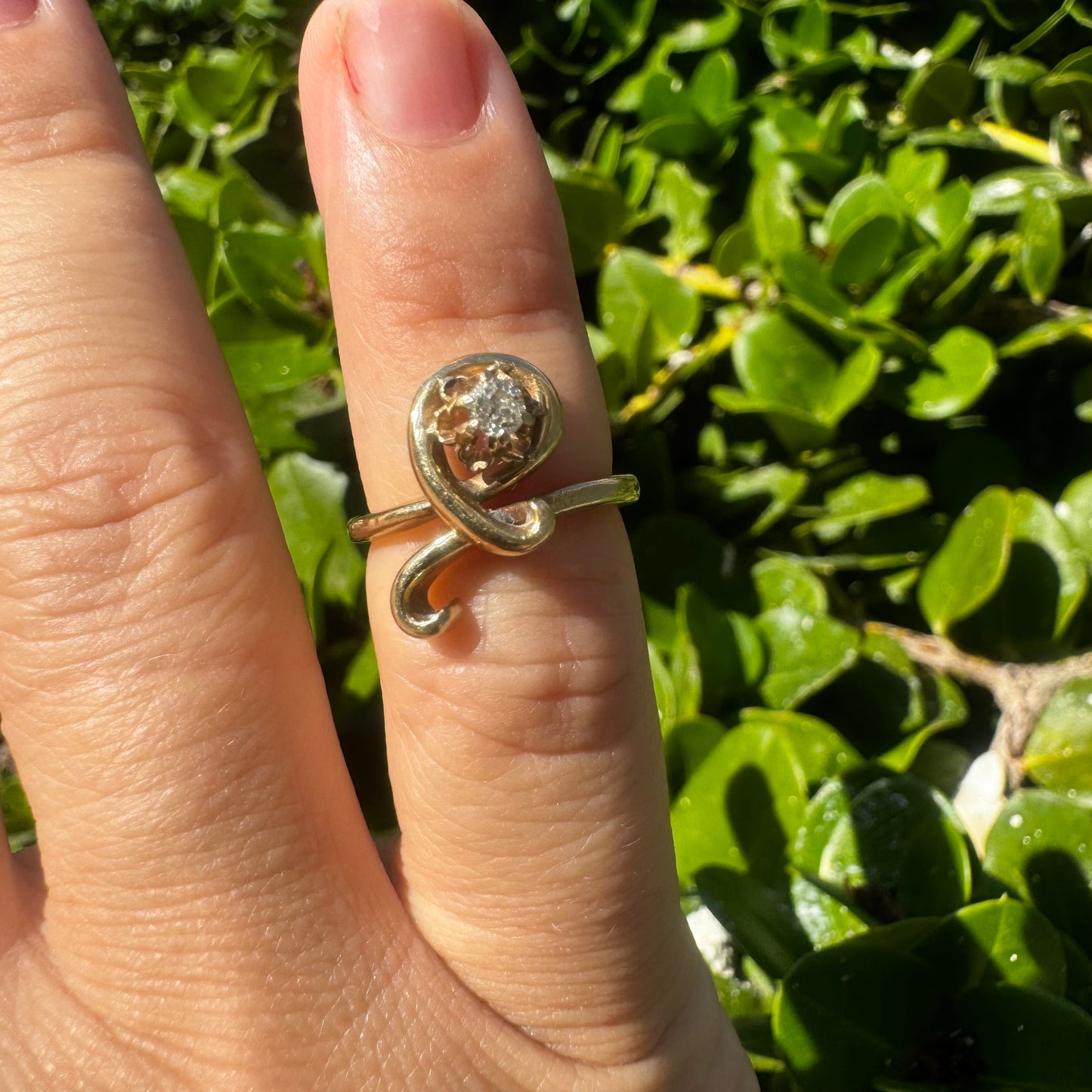 14K gold ring set with a brilliant-cut Diamond, embraced by a flowing, sculptural gold design