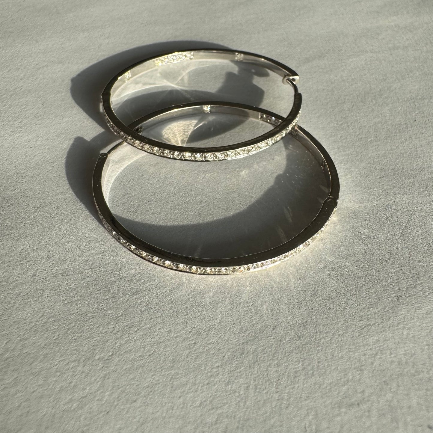 עגילי חישוק זהב 18 קראט, משובצים יהלומים לכל אורכם בחזית ובחלק הפנימי.