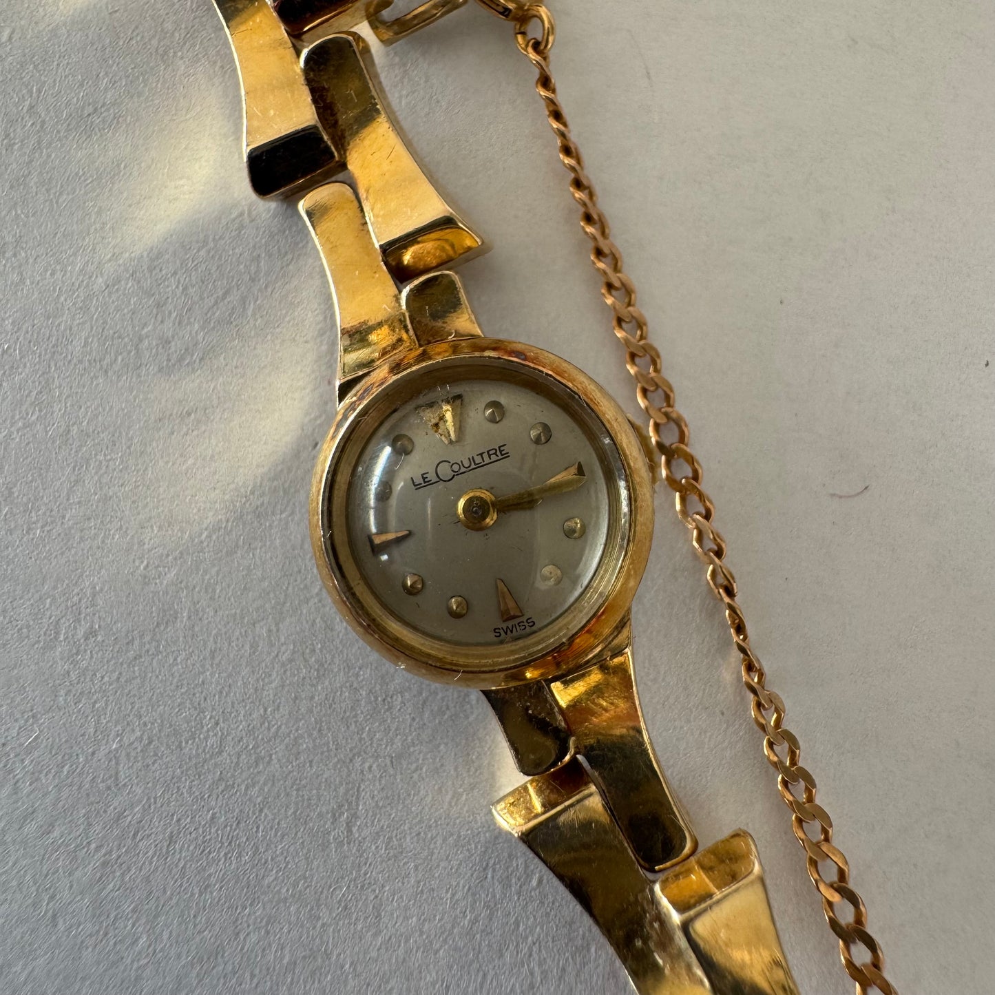 שעון נשים של Jaeger-LeCoultre מזהב 18 קראט, בעל צמיד אינטגרלי בעיצוב פיסולי ולוח מחוגים מינימליסטי ואלגנטי.