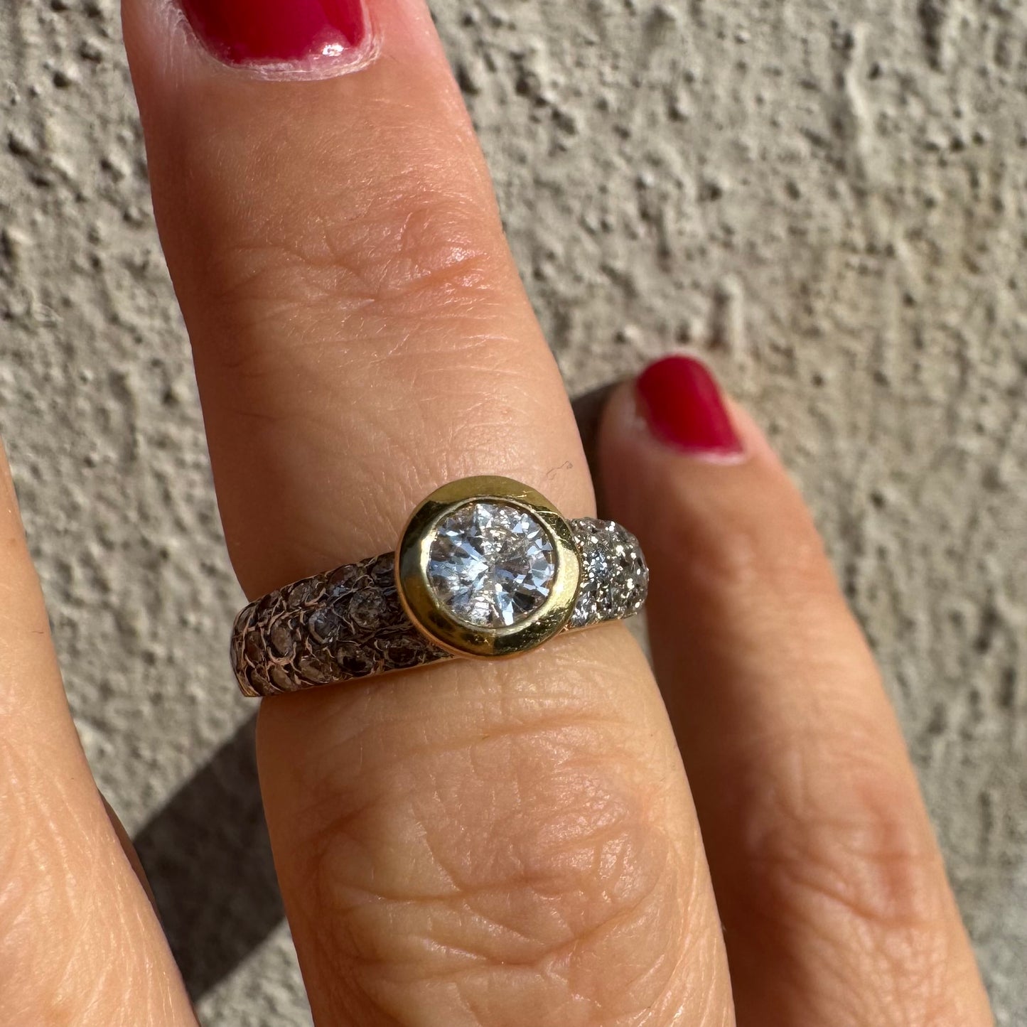 טבעת זהב צהוב 14 קראט משובצת יהלום עגול ויהלומים נוספים על הרצועה.