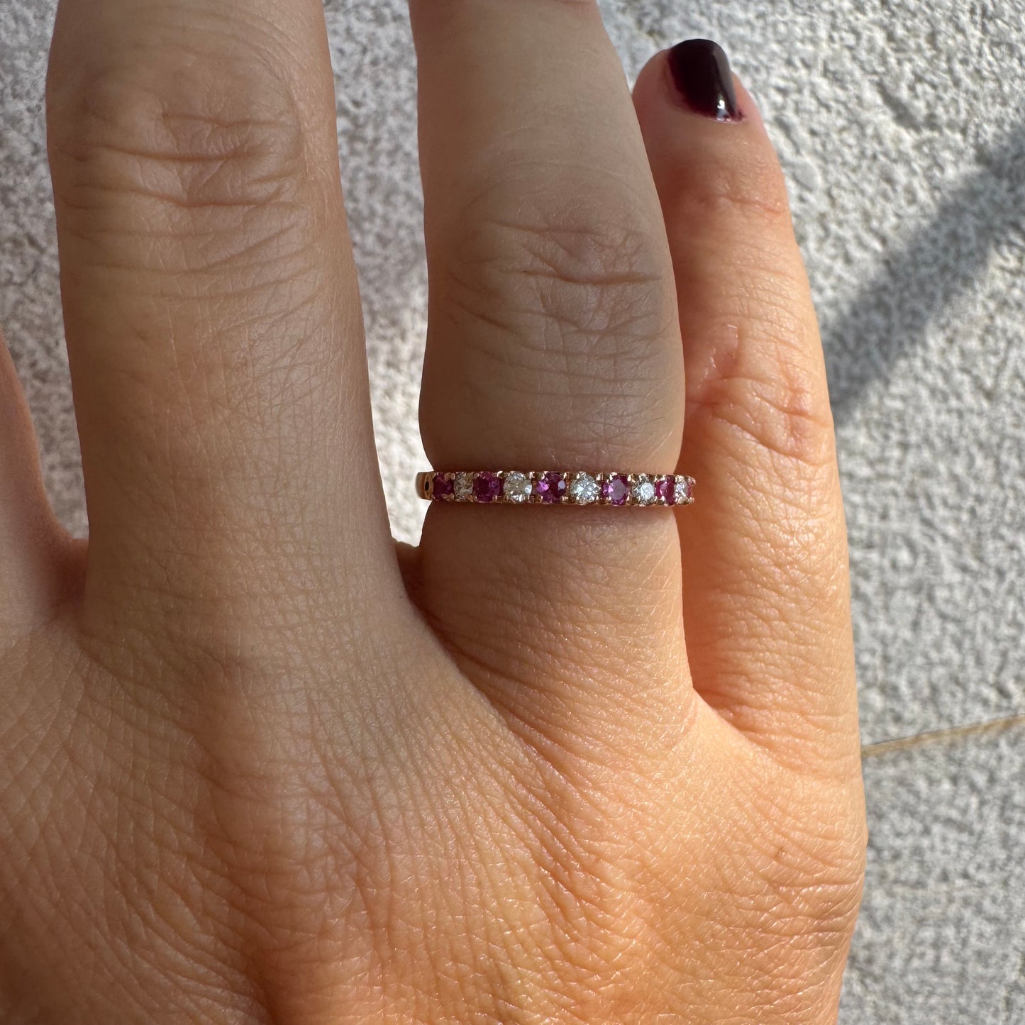 טבעת חצי איטרניטי מזהב אדום 14 קראט, משובצת ברצף של אבני רובי ויהלומים .