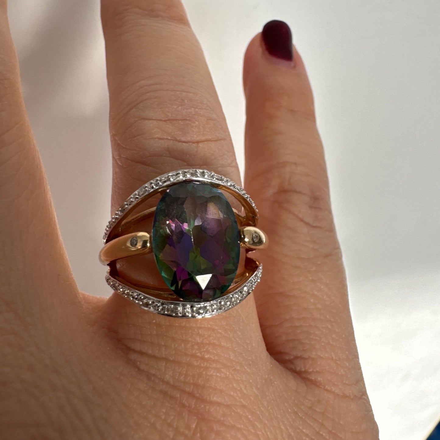 14K gold ring set with an oval Mystic Topaz