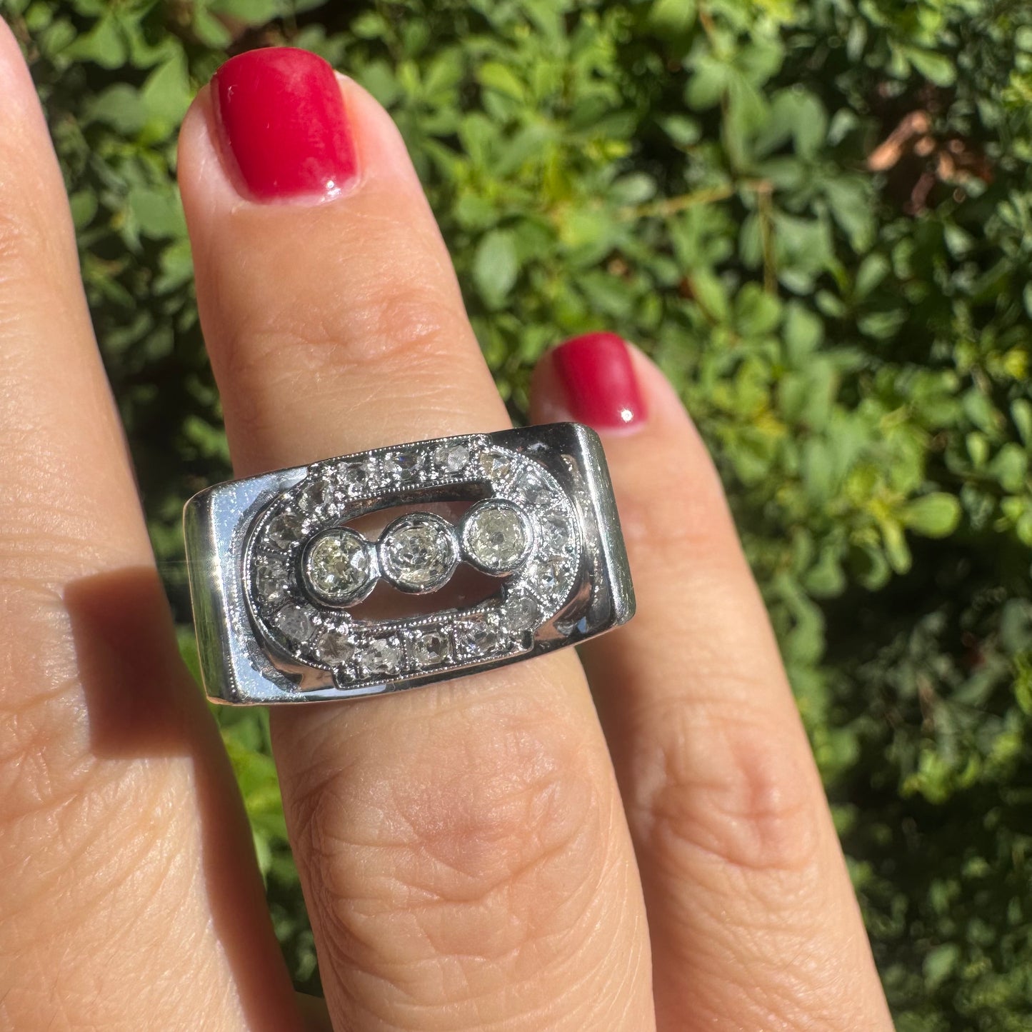 18K gold ring featuring three round 3 Diamonds in the center, framed by a rectangular halo of smaller Diamonds.