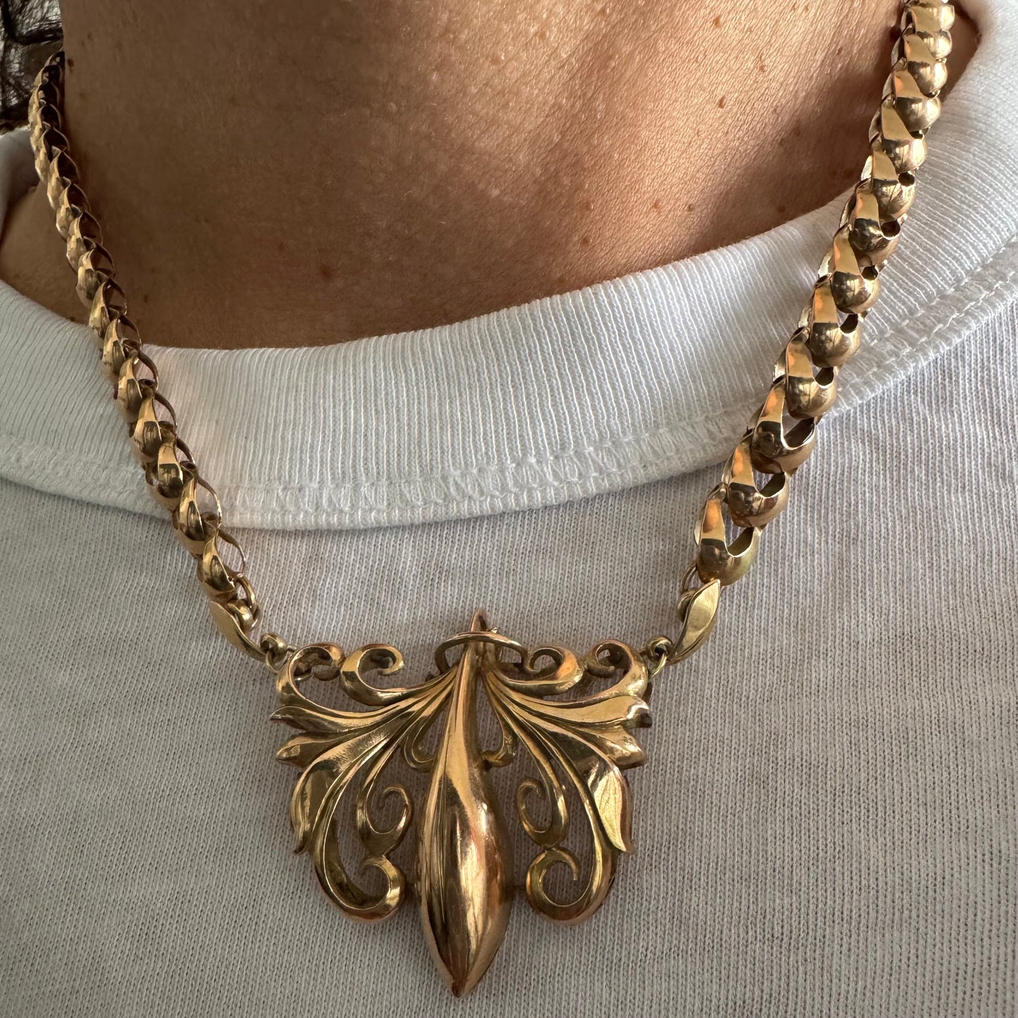 שרשרת זהב 14 קראט בעלת עיטור פלר דה ליס (Fleur-de-lis) אמנותי, המעוצב בקווים מעוגלים של עלי שושן בסגנון אר נובו.