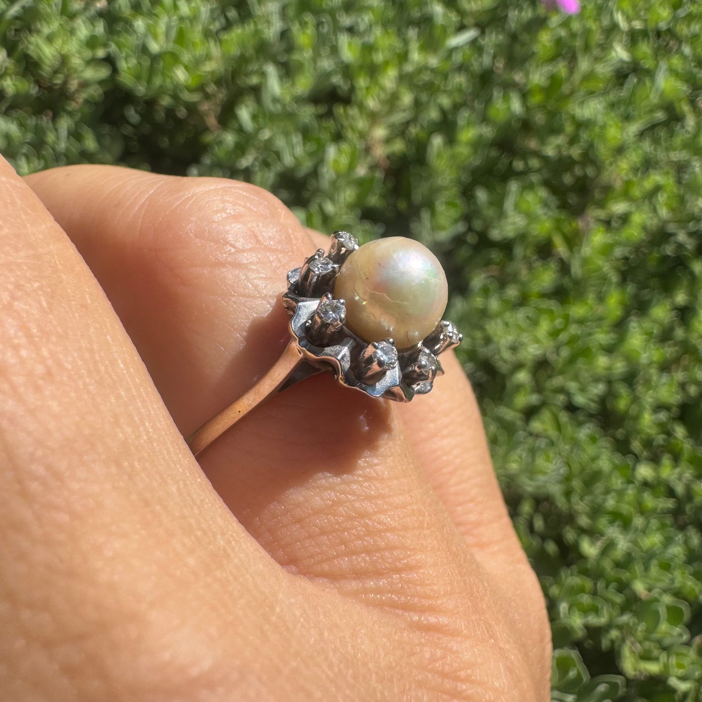 18K gold ring set with a round Pearl at the center, surrounded by a floral halo set with small Diamonds.