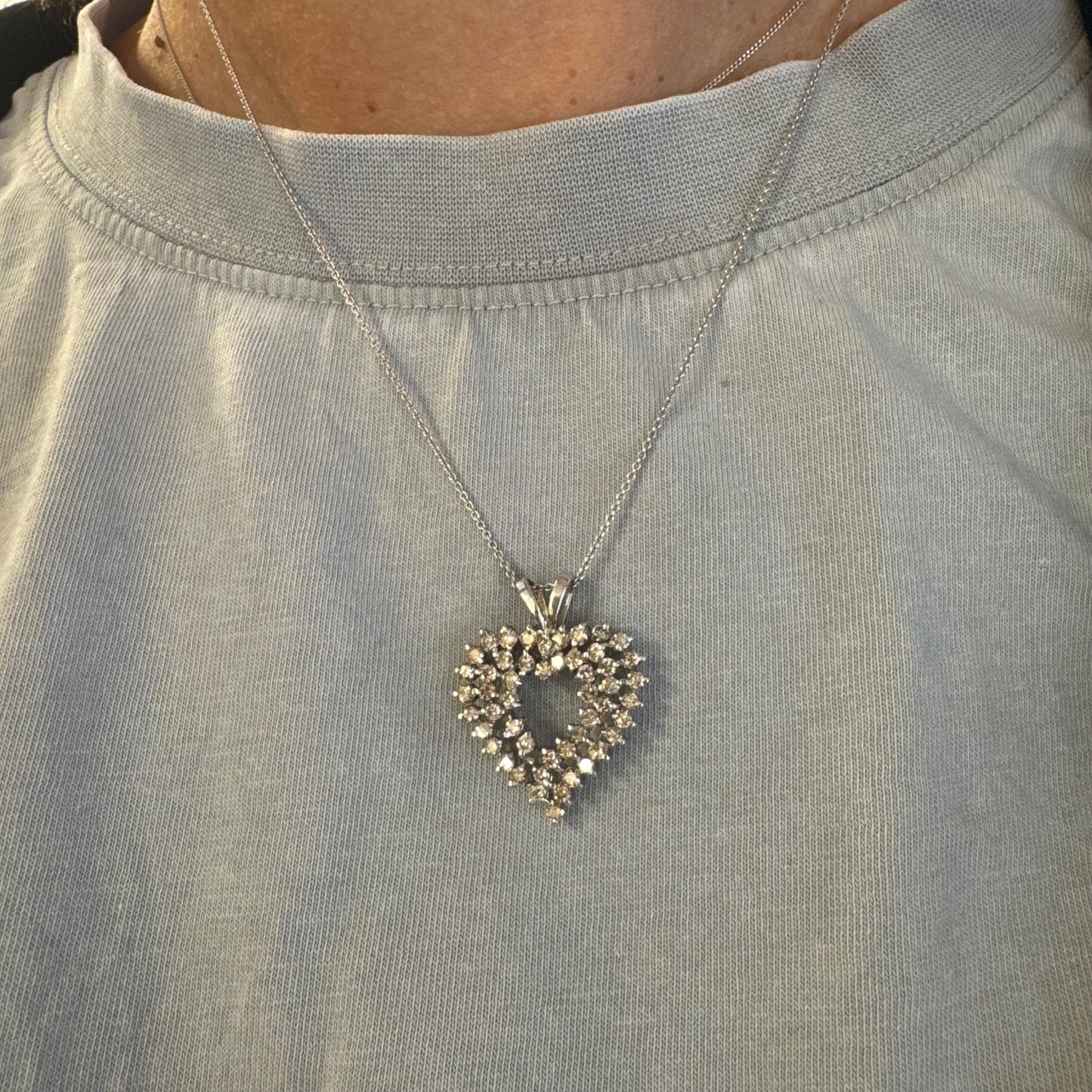 תליון לב זהב לבן 14 קראט, משובץ יהלומים בשיבוץ שיניים עדין היוצר מראה עשיר ומלא ברק.