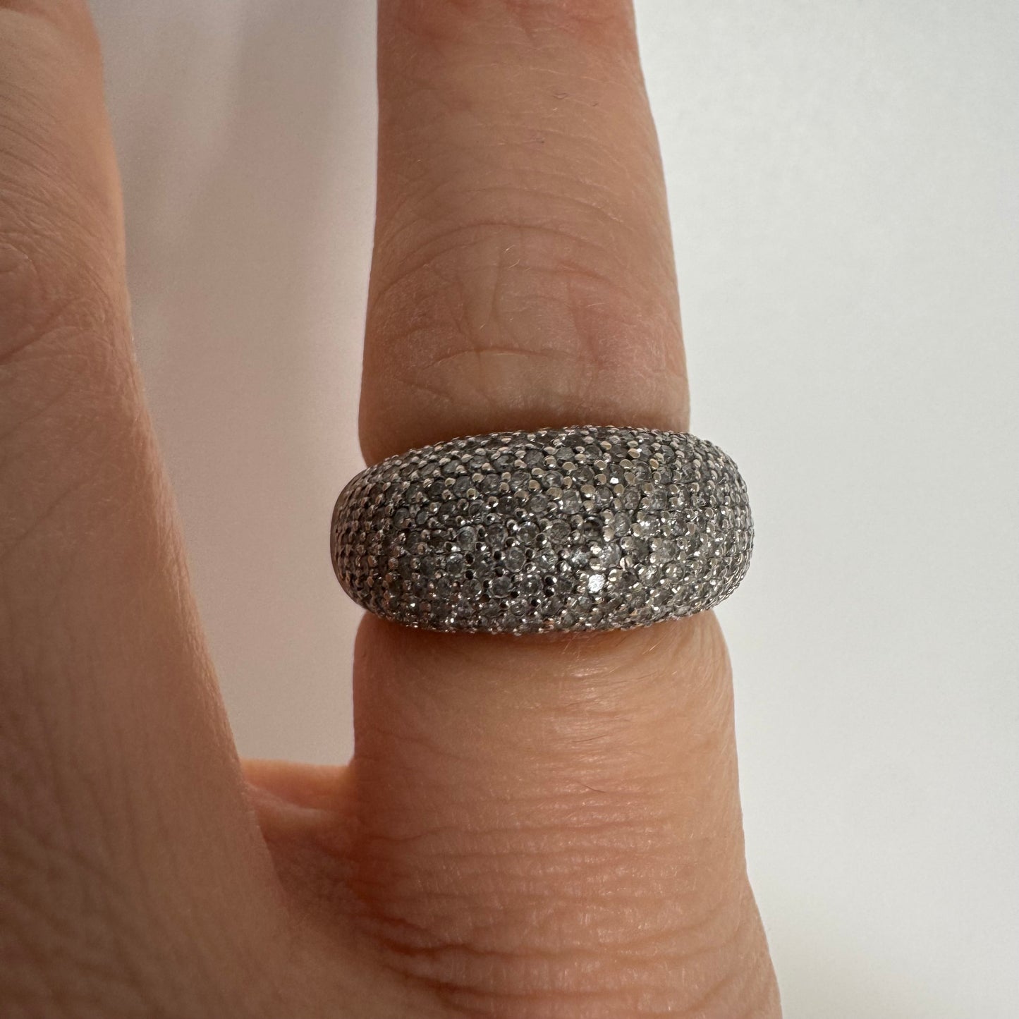 טבעת זהב לבן 14 קראט בעיצוב כיפה רחבה, משובצת יהלומים זעירים בשיבוץ פאבה צפוף.