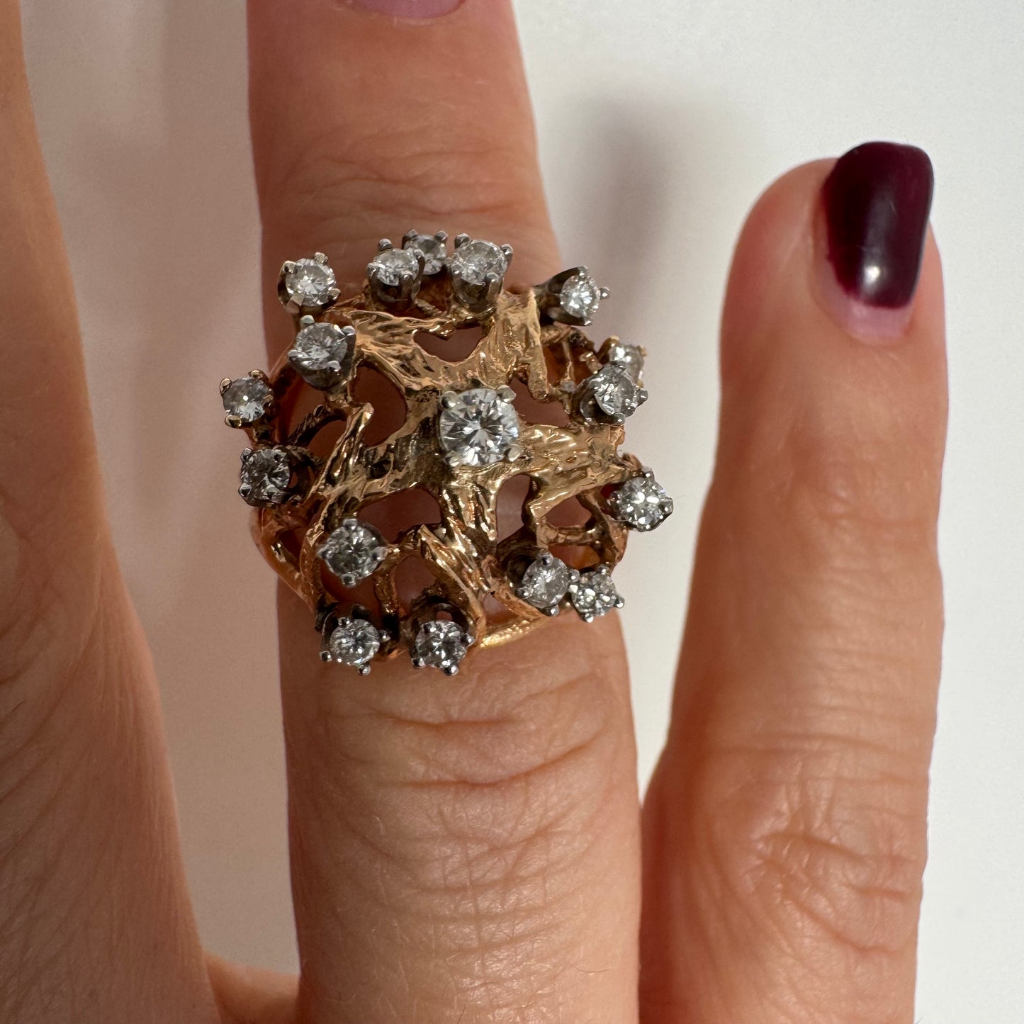 טבעת זהב 10 קראט בעיצוב פיסולי פתוח, משובצת יהלומים במבנה עגול דינמי.