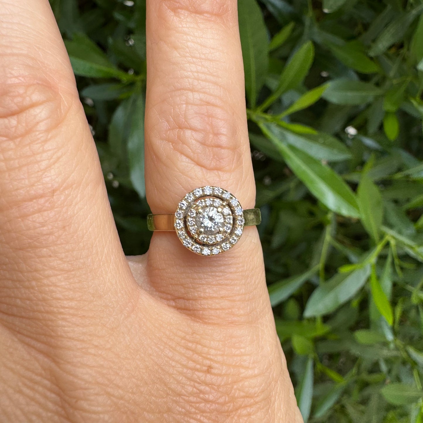 14K gold ring with a round center Diamond, surrounded by two rows of small sparkling Diamonds.
