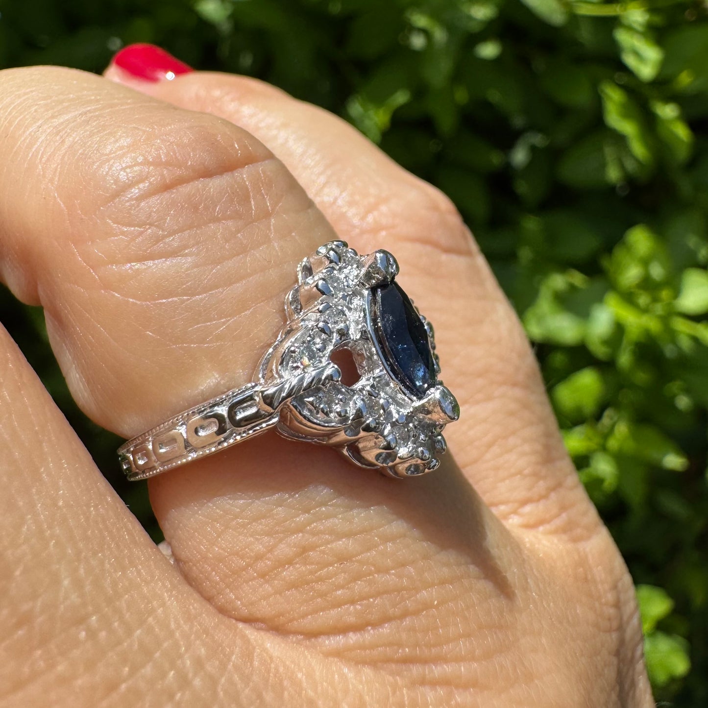 14K gold ring set with a marquise-cut Sapphire at its center, framed by an intricate halo of sparkling Diamonds