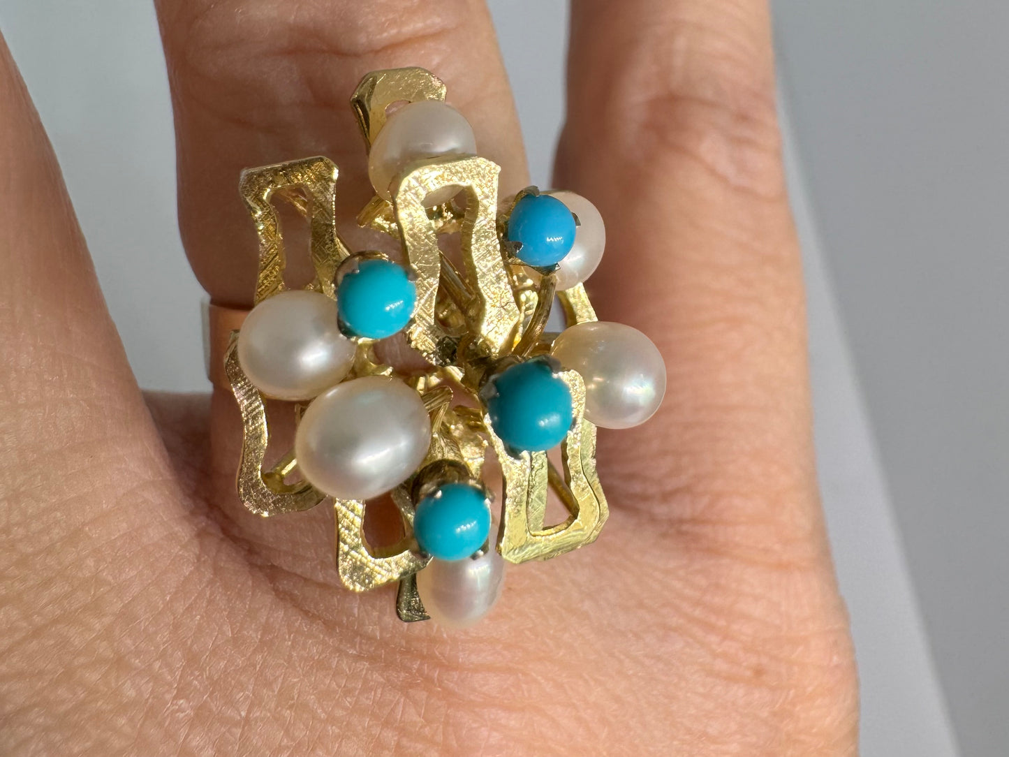 14K gold ring with a textured design, set with round white pearls and turquoise stones for a striking contrast.