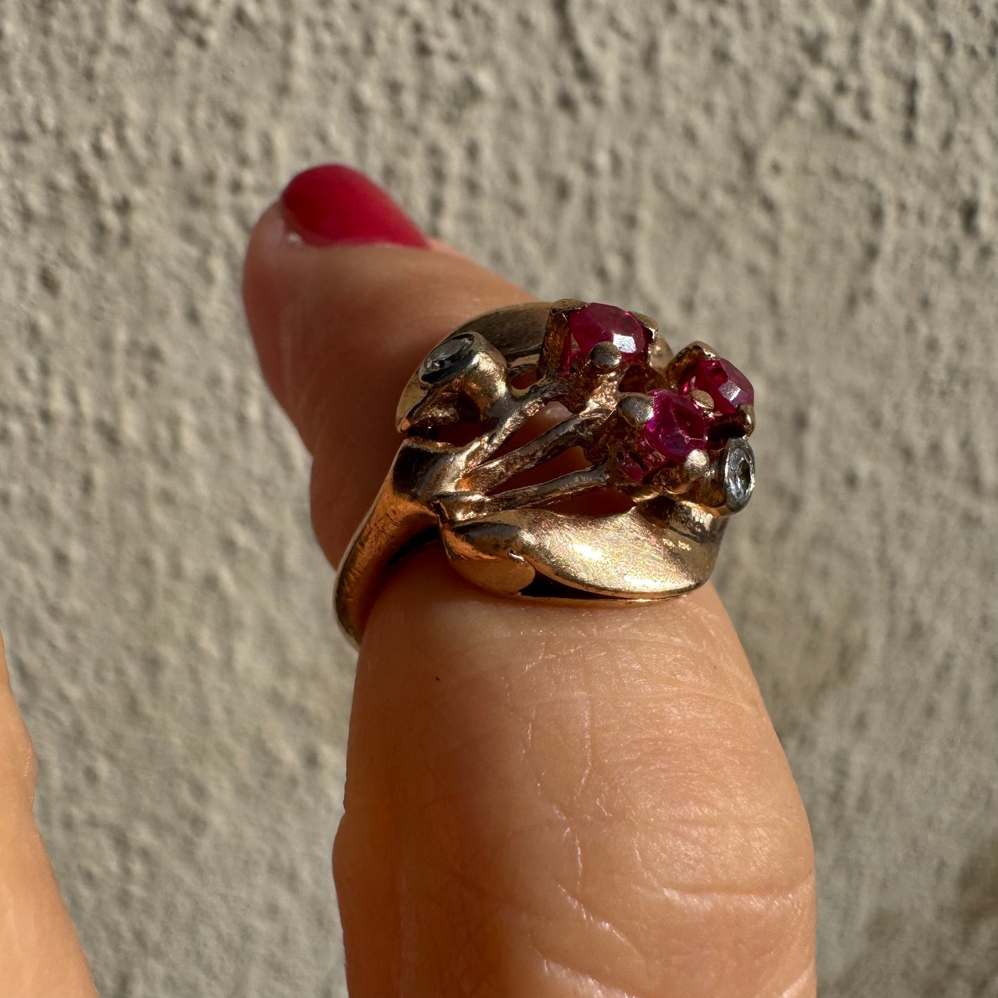 טבעת זהב צהוב 14 קראט, משובצת אבני רובי ושני יהלומים להדגשה, בעיצוב פיסולי ומלא אופי.