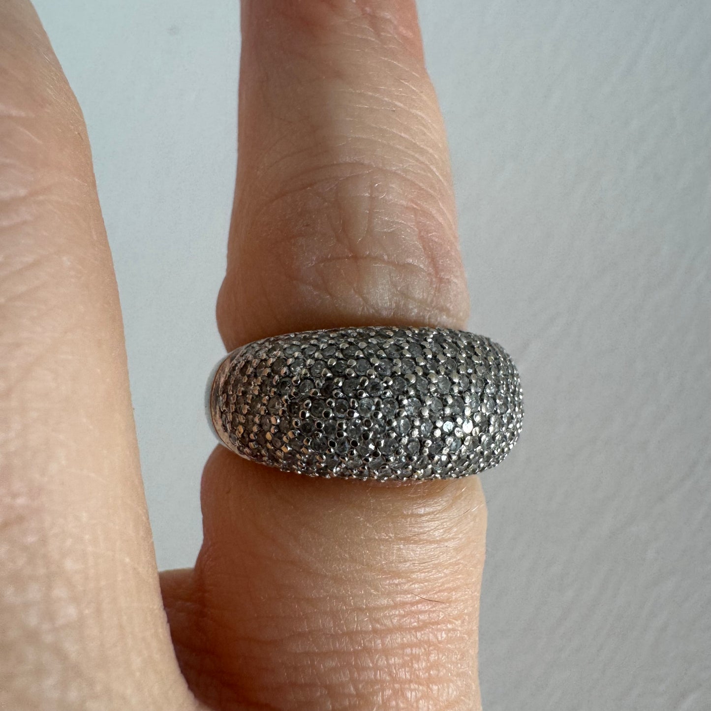 טבעת זהב לבן 14 קראט בעיצוב כיפה רחבה, משובצת יהלומים זעירים בשיבוץ פאבה צפוף.