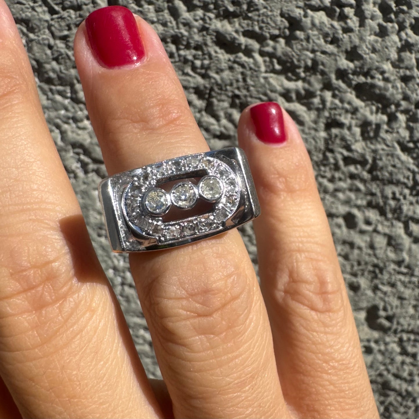 18K gold ring featuring three round 3 Diamonds in the center, framed by a rectangular halo of smaller Diamonds.
