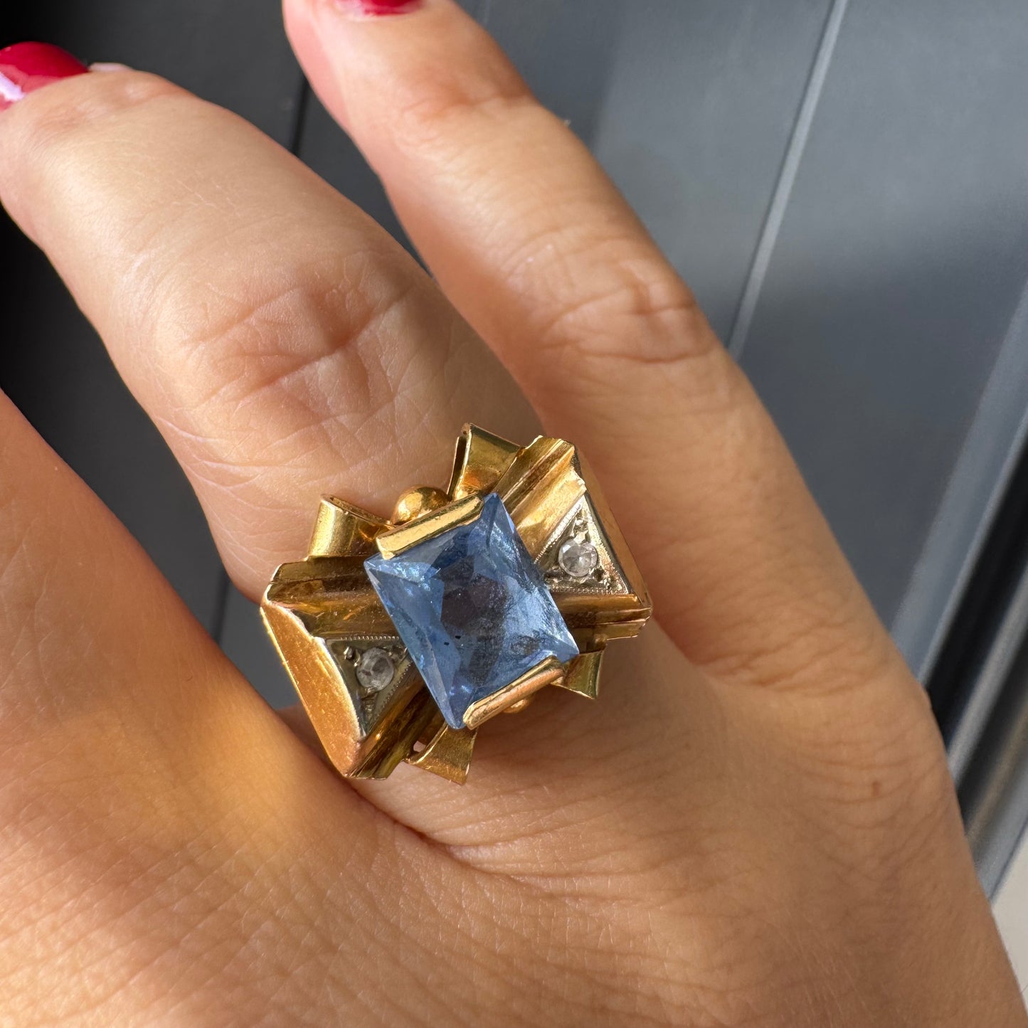 טבעת זהב צהוב 18 קראט בעיצוב פפיון משובצת אבן טופז כחולה בחיתוך מלבני במרכז