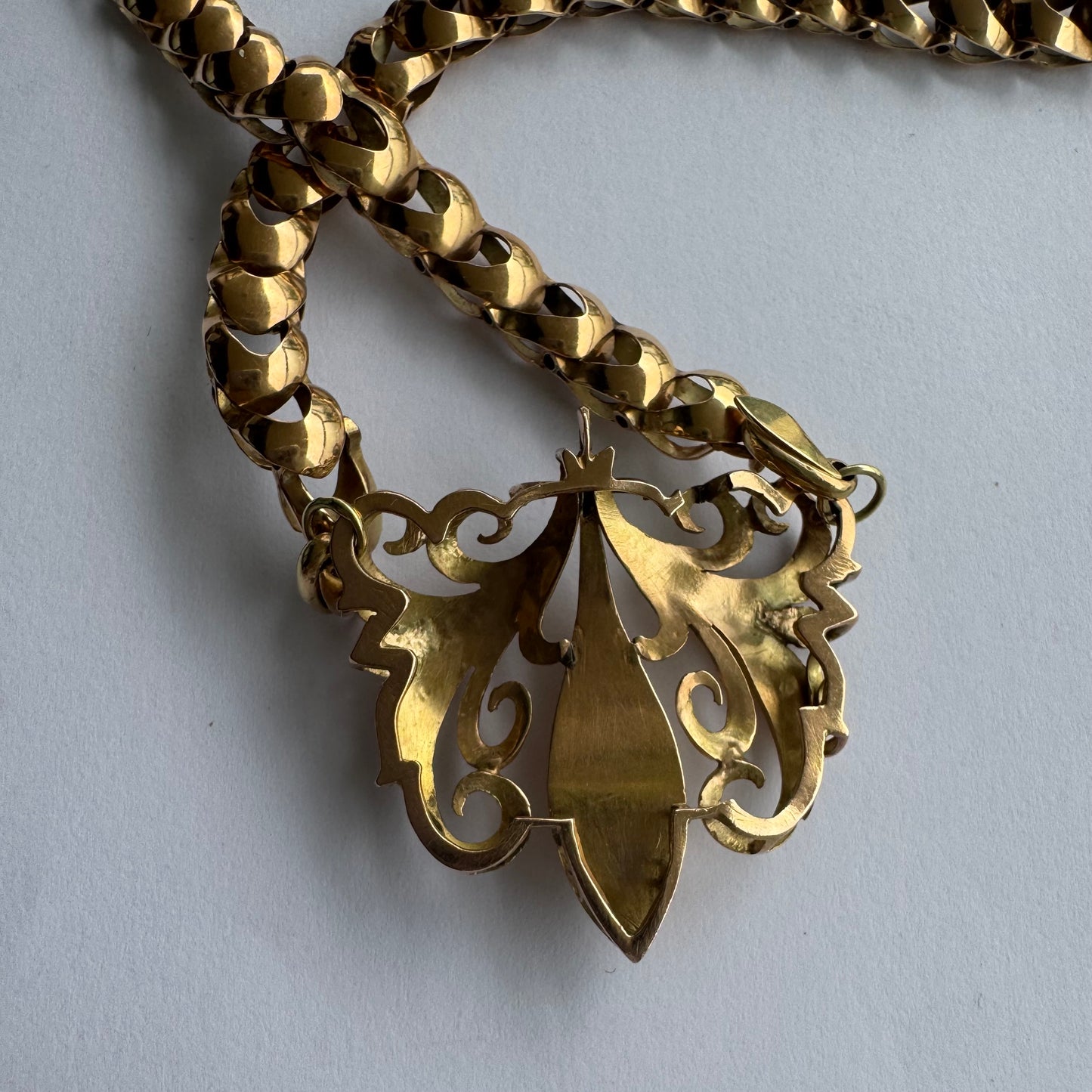 שרשרת זהב 14 קראט בעלת עיטור פלר דה ליס (Fleur-de-lis) אמנותי, המעוצב בקווים מעוגלים של עלי שושן בסגנון אר נובו.