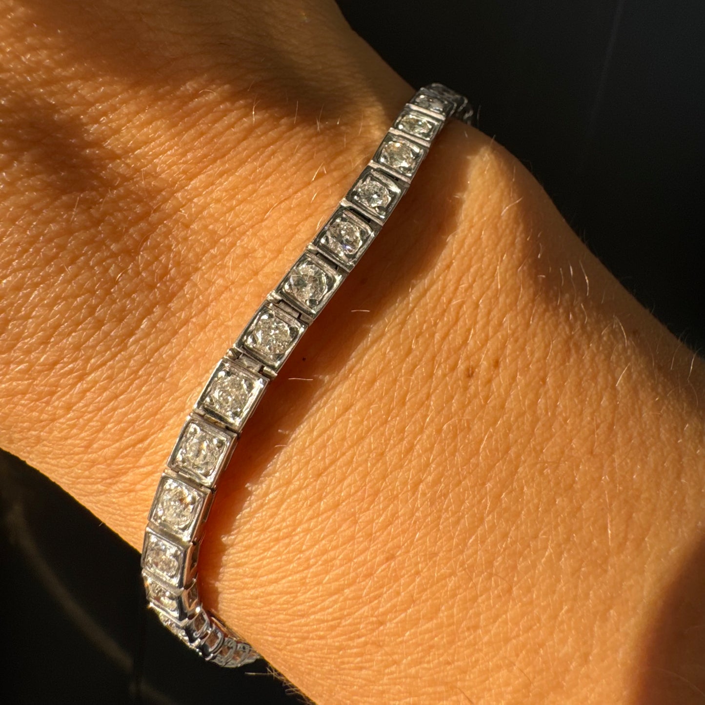 צמיד טניס זהב לבן 18 קראט משובץ יהלומים עגולים נוצצים בתוך מסגרות ריבועיות.