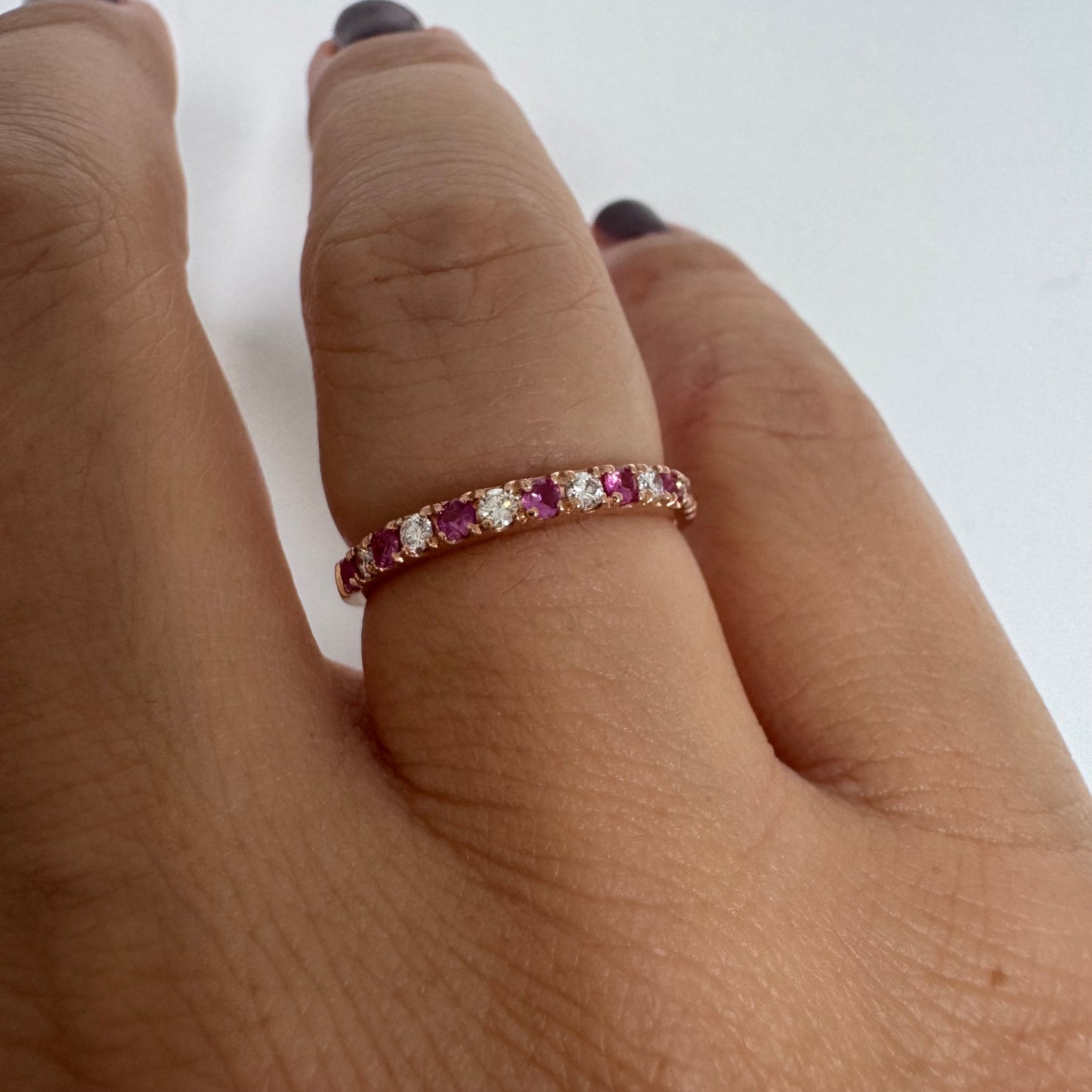 טבעת חצי איטרניטי מזהב אדום 14 קראט, משובצת ברצף של אבני רובי ויהלומים .