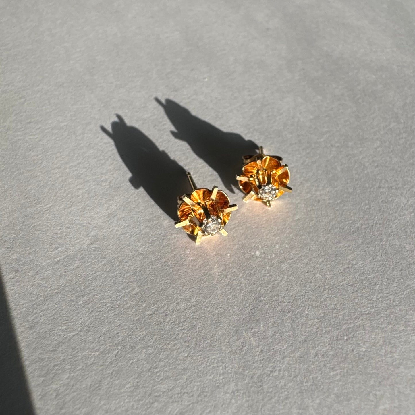 עגיל צמוד זהב צהוב 14 קראט בעיצוב פרח עדין, עם יהלום לבן במרכזו.