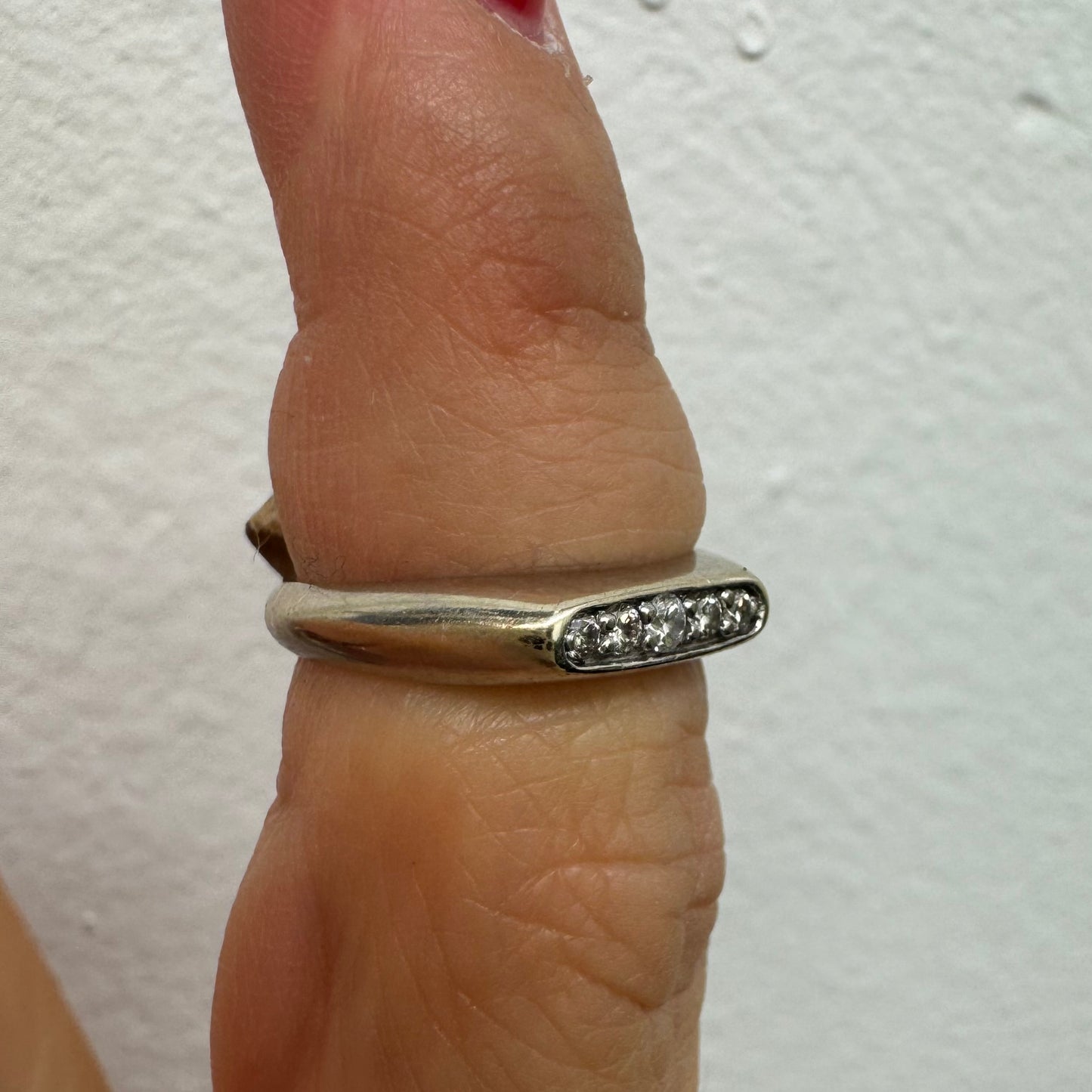 טבעת זהב לבן 14 קראט, בעיצוב עדין וקלאסי, משובצת שורת יהלומים קטנים במסגרת חלקה ונוחה לענידה יומיומית. 