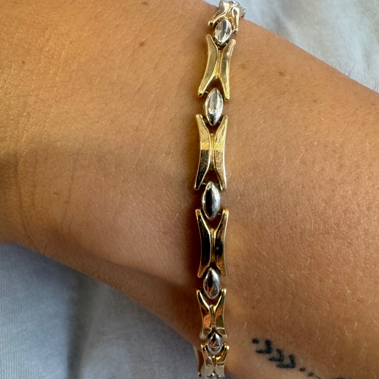 צמיד זהב צהוב וזהב לבן 14 קראט בעיצוב גאומטרי מיוחד, עם חיבורים בצורת X מזהב צהוב ושיבוצים מבריקים בזהב לבן