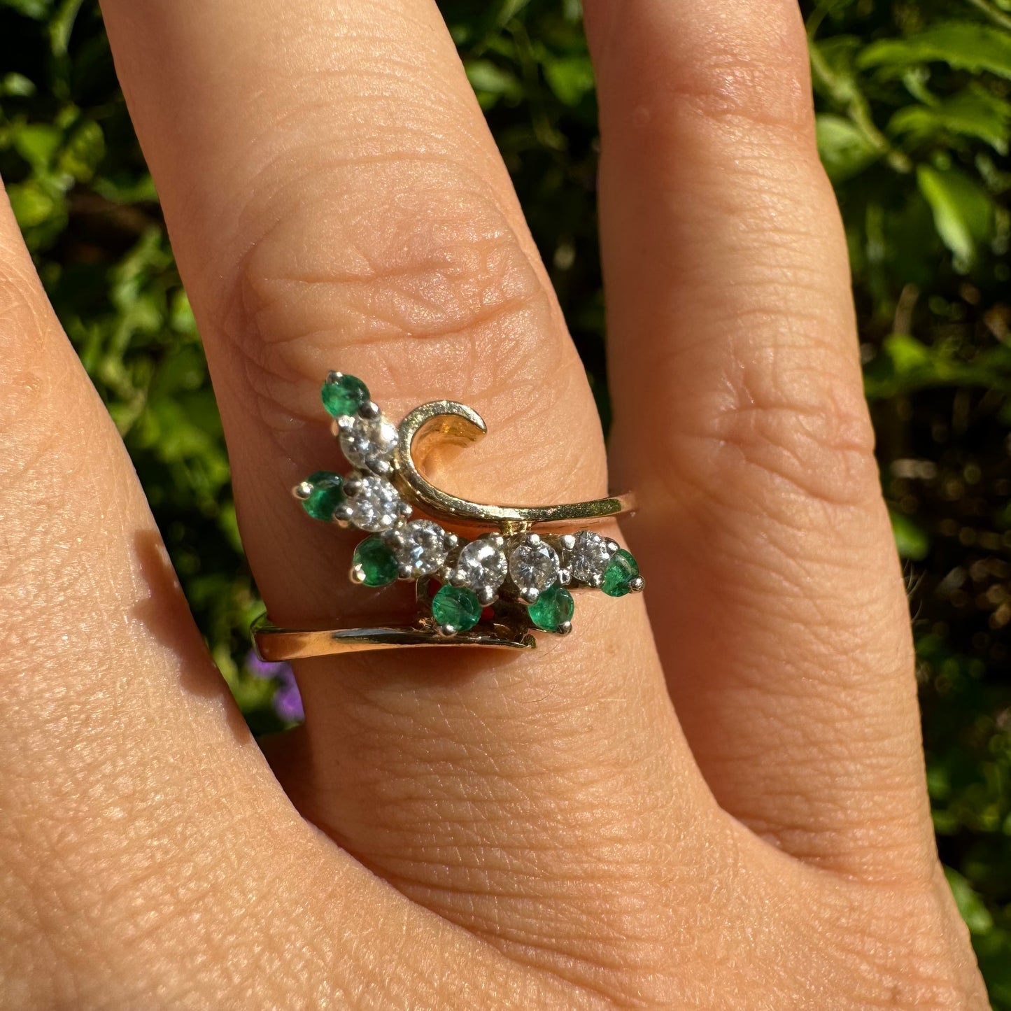 14K gold open ring featuring a delicate swirl set with Emeralds and brilliant-cut Diamonds