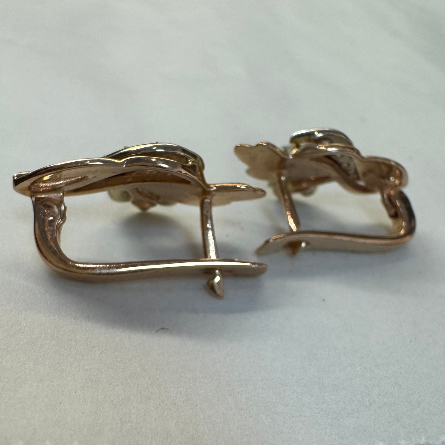 עגילי זהב 14 קראט בעיצוב מתעגל ואלגנטי המשובצים יהלומים נוצצים .