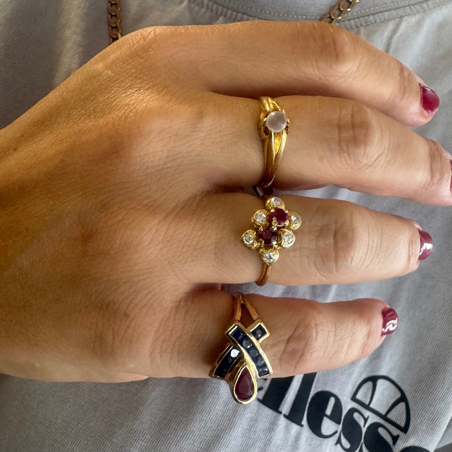 10K gold ring set with a pear-shaped Ruby and deep blue Sapphires in a geometric design.