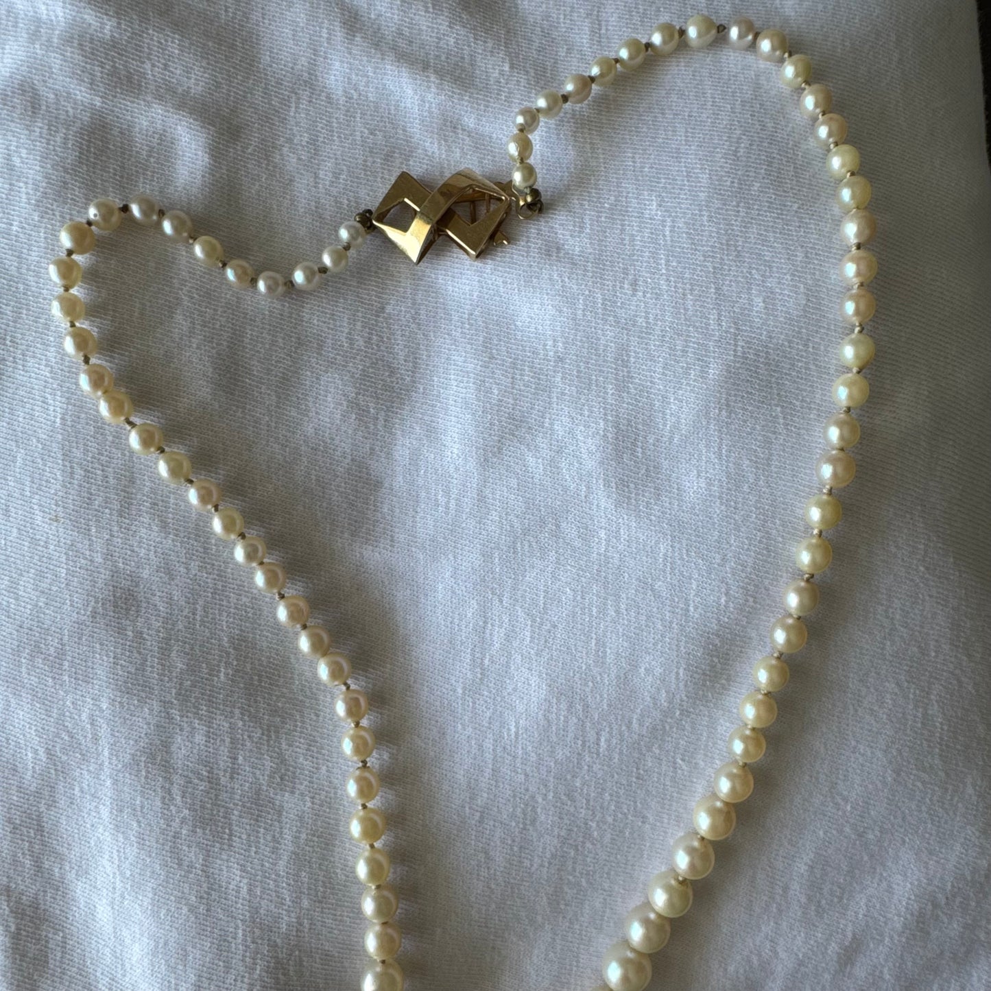 שרשרת פנינים קלאסית עם סוגר גאומטרי מזהב צהוב 14 קראט.