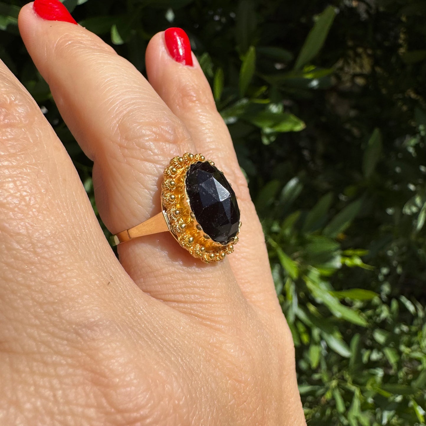 14K gold ring set with a large Garnet surrounded by delicate gold details