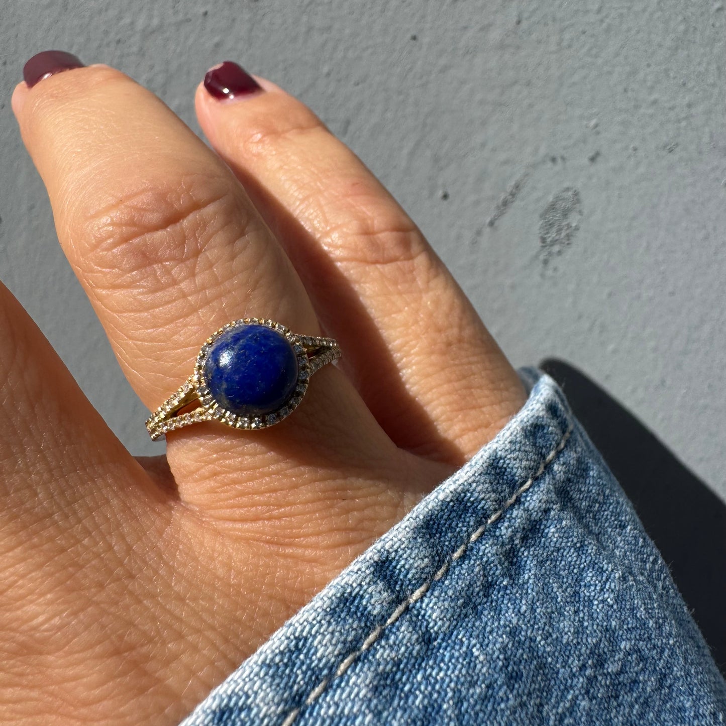 14K gold ring set with a round Lapis Lazuli gemstone, surrounded by a delicate halo of sparkling Diamonds.