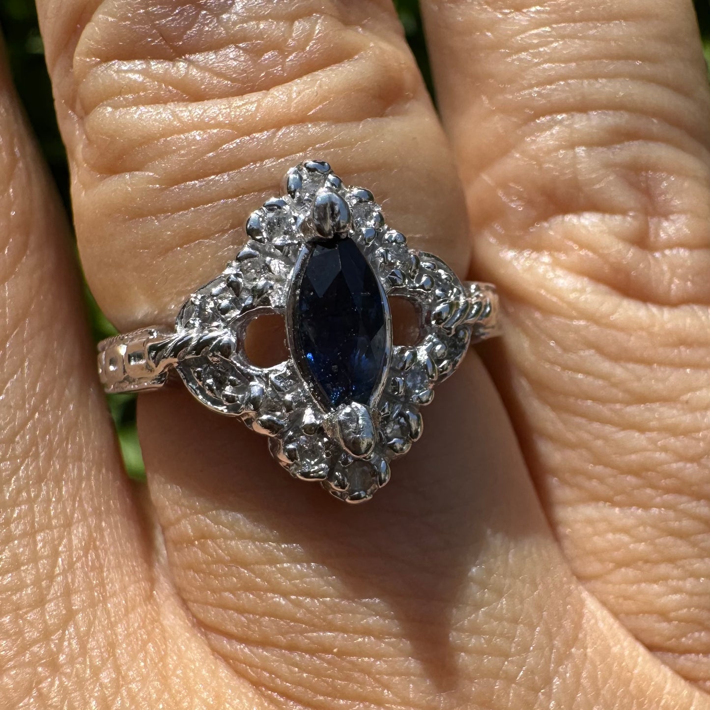 14K gold ring set with a marquise-cut Sapphire at its center, framed by an intricate halo of sparkling Diamonds