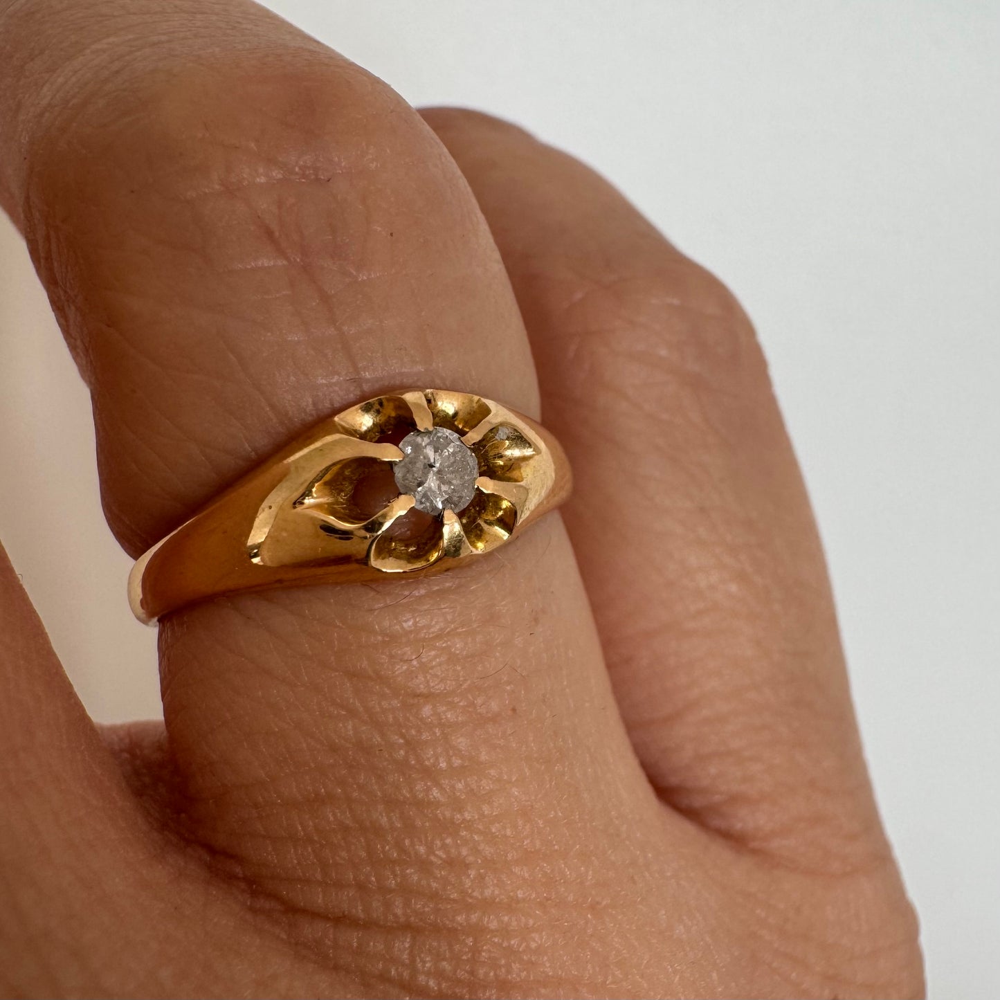 טבעת זהב צהוב 18 קראט בעיצוב פרח עדין, משובצת יהלום מרכזי בתוך עלי כותרת פתוחים.