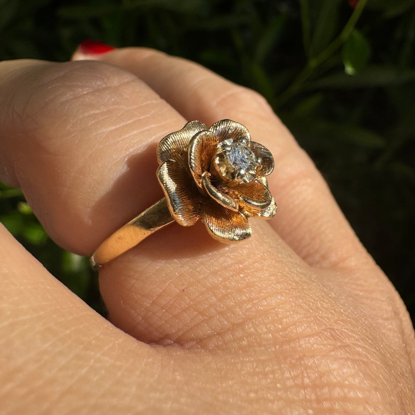 14K Gold floral ring set with delicately textured petals and a sparkling Diamond at the center
