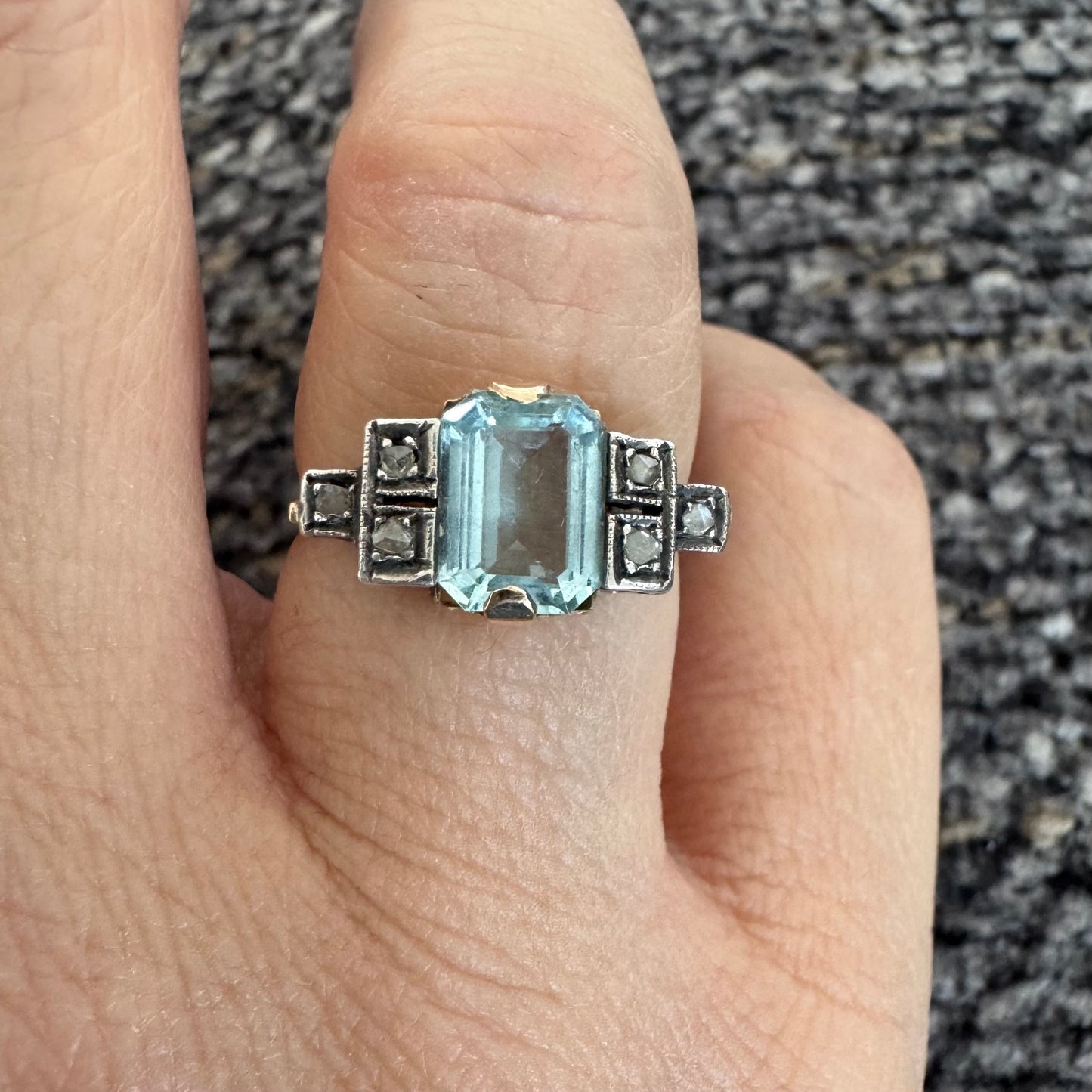 טבעת עתיקה מזהב 14 קראט, משובצת אבן אקוומרין מרכזית בחיתוך מלבני ויהלומים.