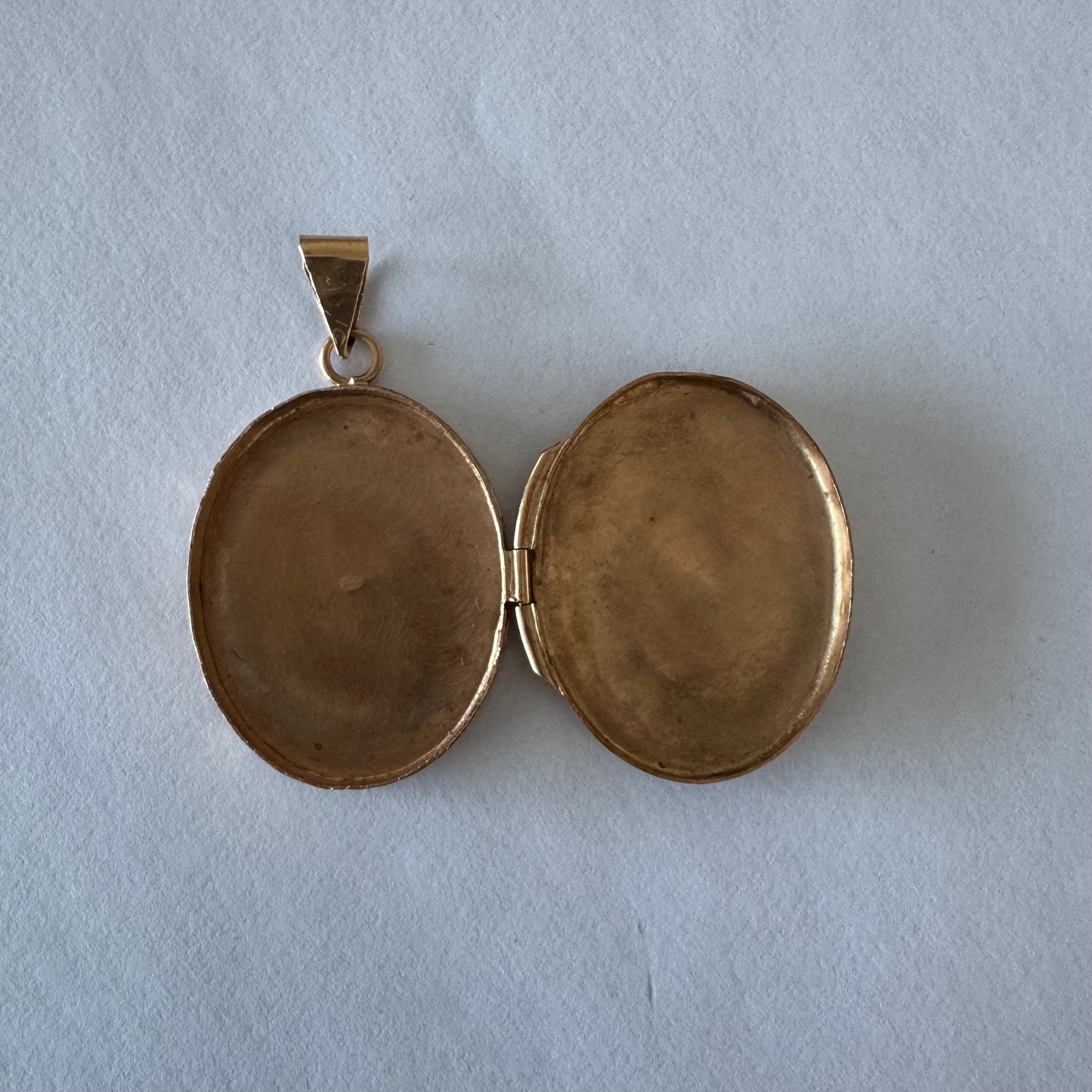 תליון לוקט זהב 14 קראט אובלי עם עיטור חריטה פרחית עדינה בעבודת יד ומסגרת אלגנטית ופתיחה לשמירת זיכרון קטן ויקר ללב.