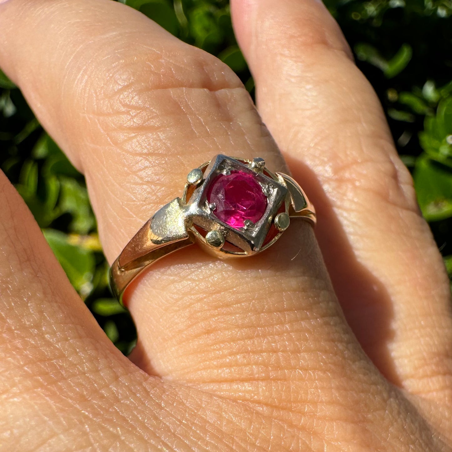 14K gold ring set with a vivid round-cut Ruby set in a geometric white gold frame.