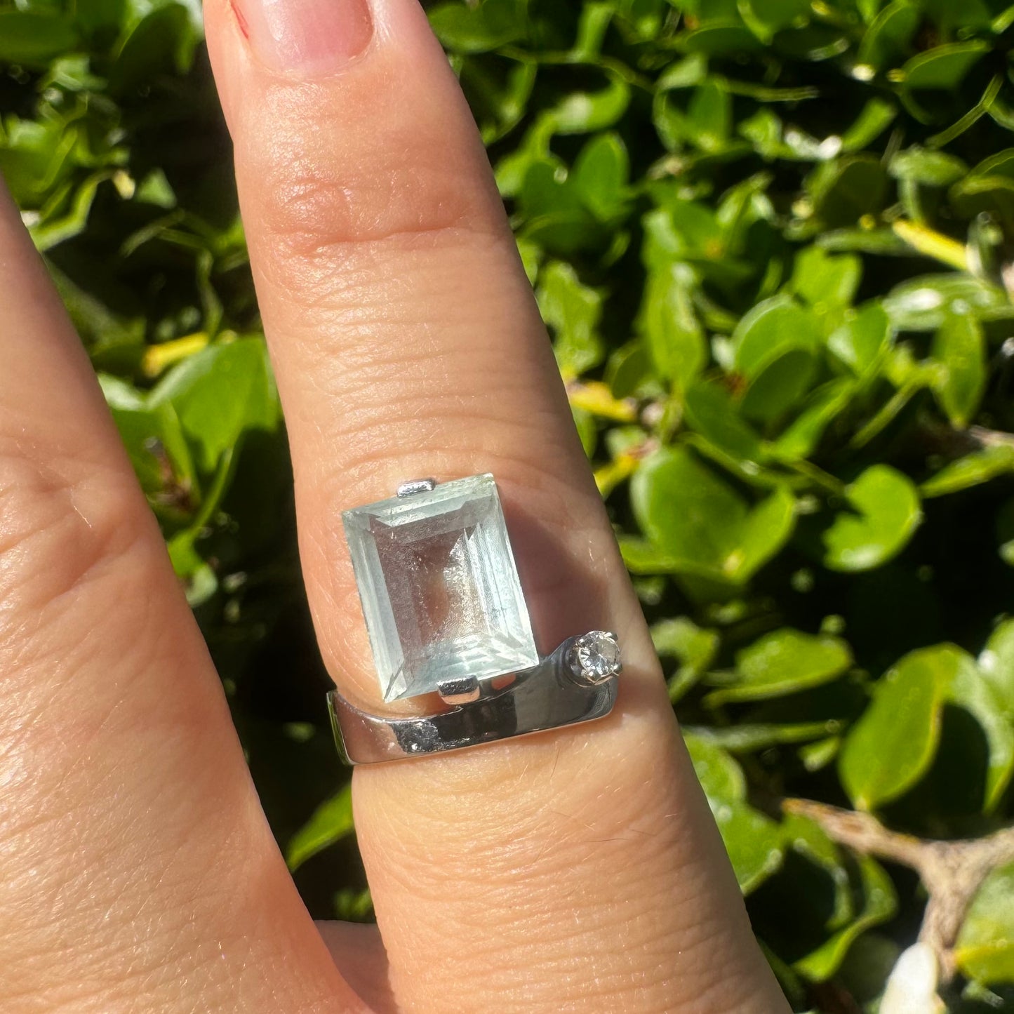 18K gold ring set with a rectangular step-cut Aquamarine set in a sculptural white gold band & a sparkling Diamond