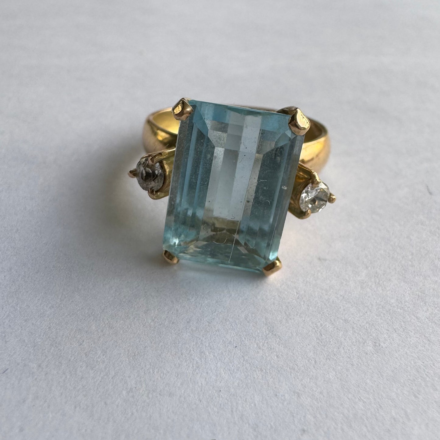 טבעת זהב 18 קראט משובצת אבן אקוומרין בחיתוך מלבני (Emerald Cut), בעלת גוון כחול צלול ומרשים.