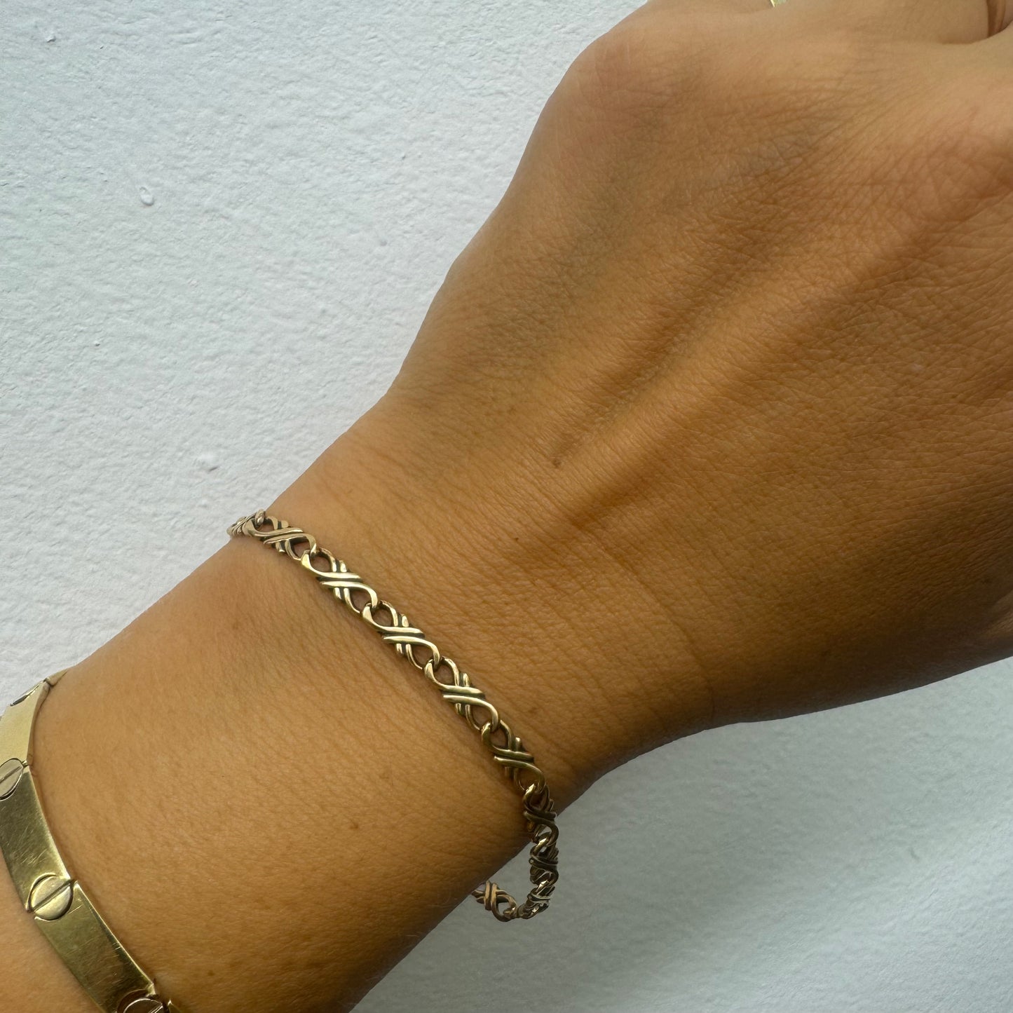 צמיד זהב צהוב 14 קראט עם חוליות שזורות בעיצוב שזירה ופיתול, וסוגר מסוג לובסטר.